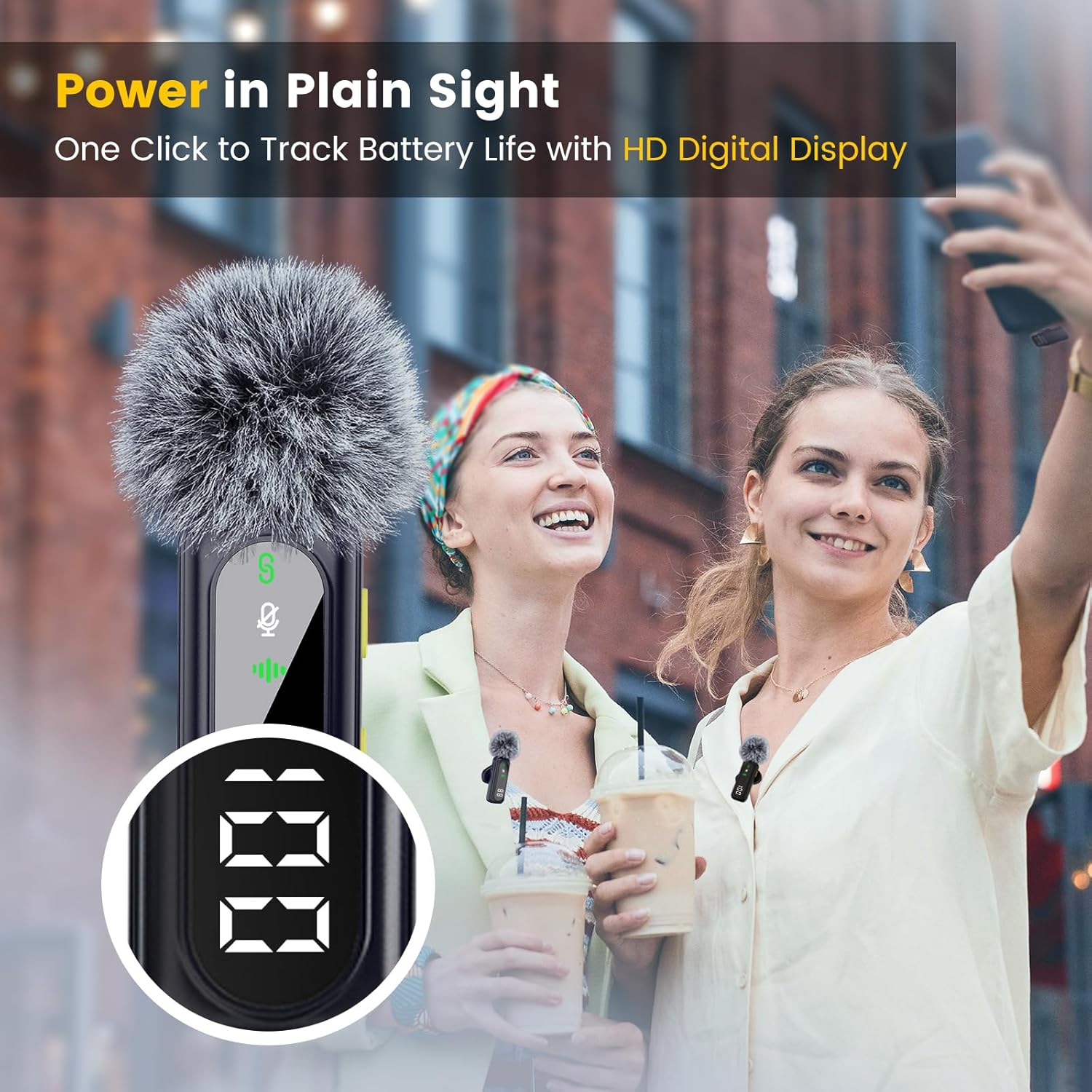 Zwei Frauen machen ein Selfie mit Mikrofonen, halten Eisgetränke. Ein digitales Display zeigt die Akkulaufzeit. Hintergrund sind Gebäude.