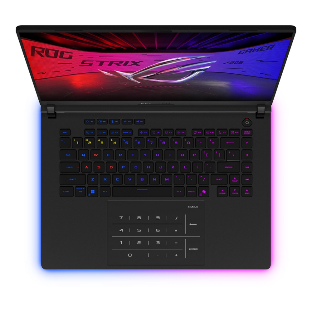 Un laptop nero è aperto, mostrando una tastiera colorata. Lo schermo mostra il logo ROG STRIX. La tastiera è retroilluminata in più colori.