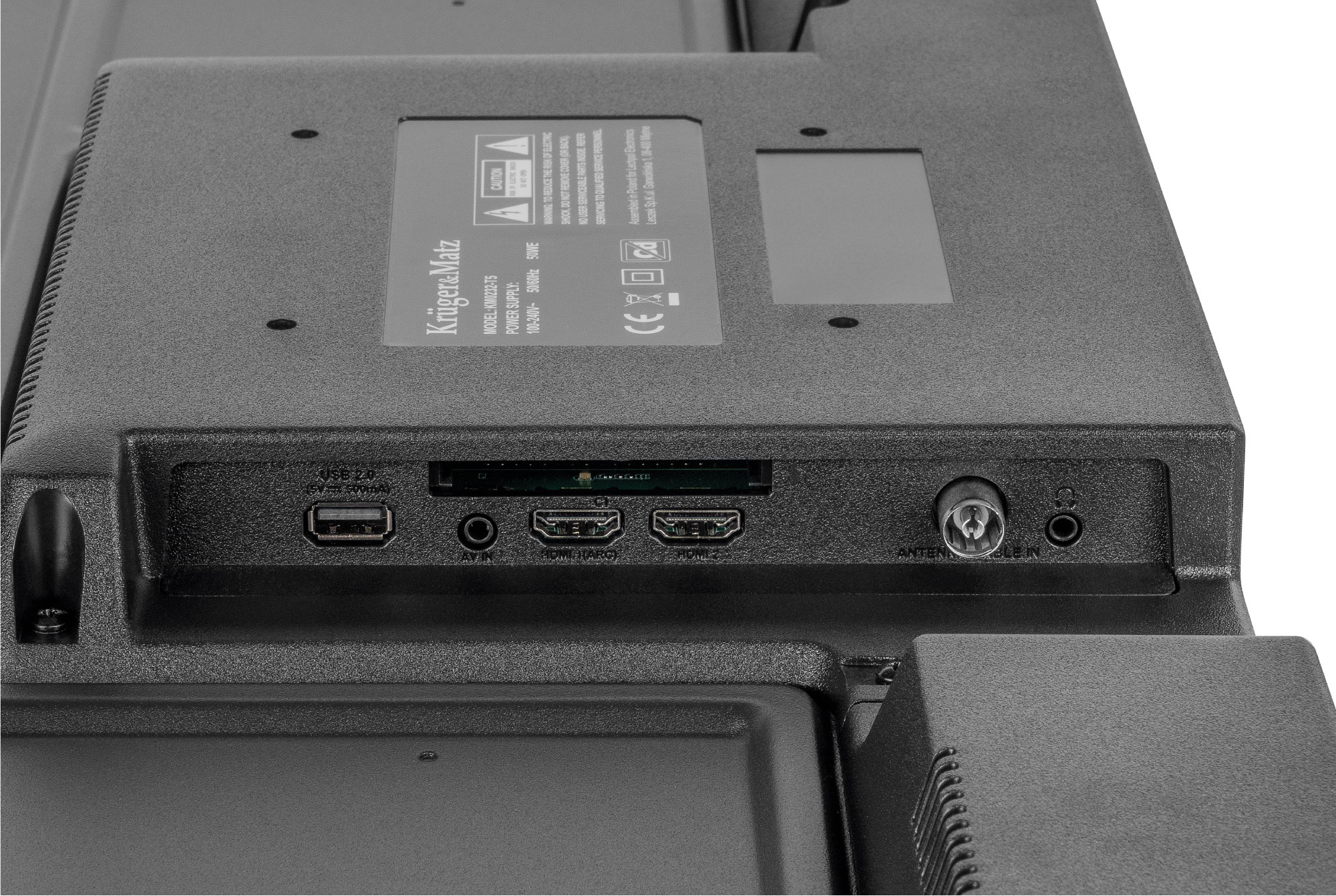 Tylny panel telewizora Krüger&Matz z różnymi portami i etykietami, w tym USB, HDMI i anteną. Panel jest czarny.
