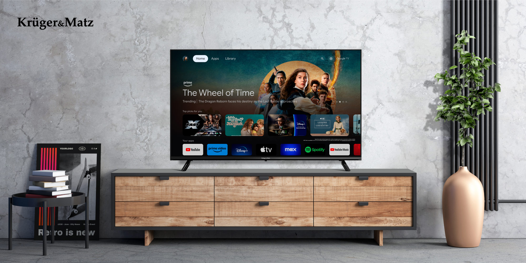 Telewizor wyświetla 'The Wheel of Time'. Stoi na drewnianej szafce. Roślina po prawej, stolik po lewej. Betonowa ściana.