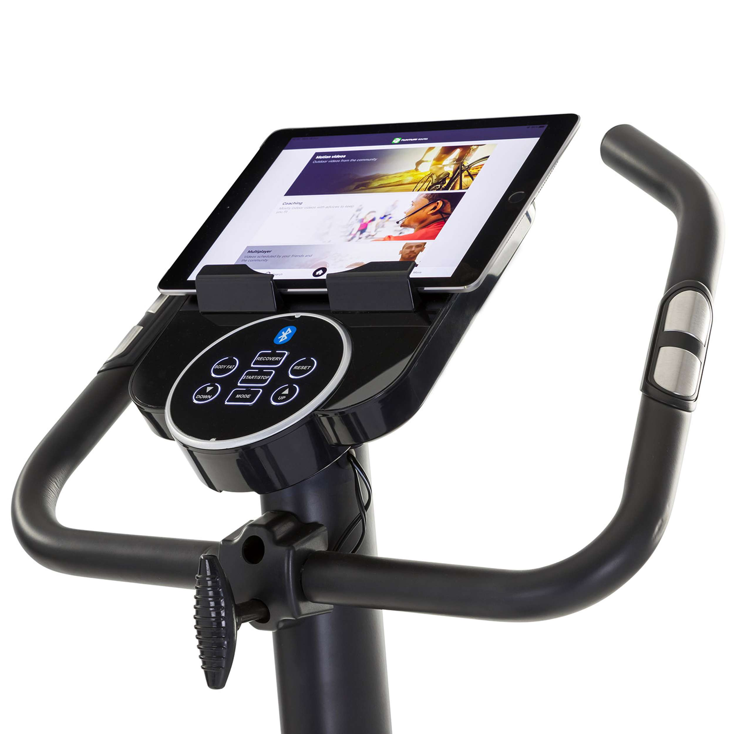 Hometrainer met tablet die een fitness app interface toont. Zwart frame, zilveren accenten en bedieningspaneel zijn zichtbaar.