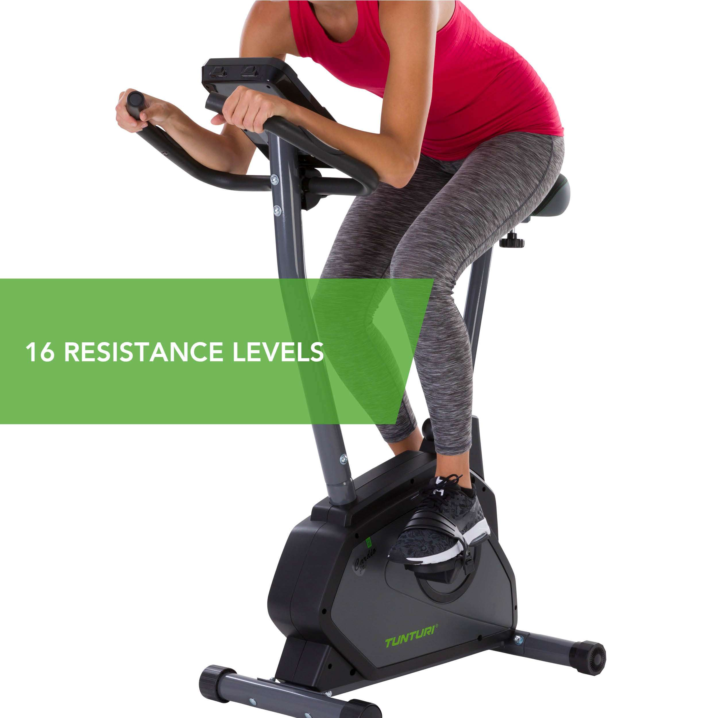 Een persoon sport op een hometrainer. De fiets is grijs en zwart. De persoon draagt een rode top en grijze legging.