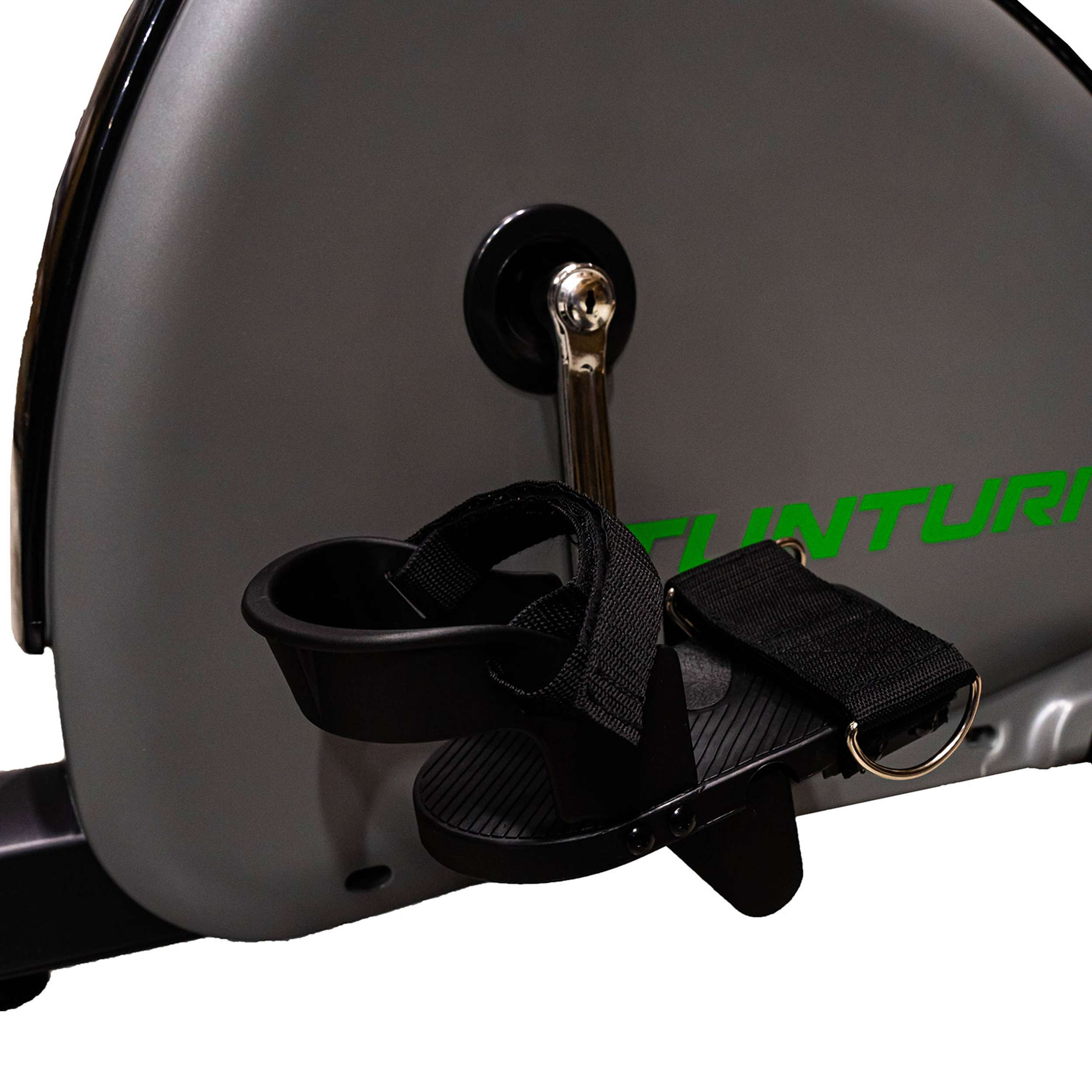 Primo piano del pedale di una cyclette. Pedale nero con cinturino, telaio grigio e logo 'TUNTURI' verde.