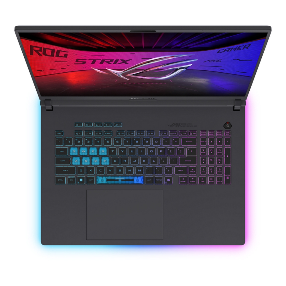 Vista dall'alto di un laptop scuro con tastiera illuminata. Lo schermo mostra il marchio ROG STRIX. I tasti della tastiera sono illuminati in vari colori.