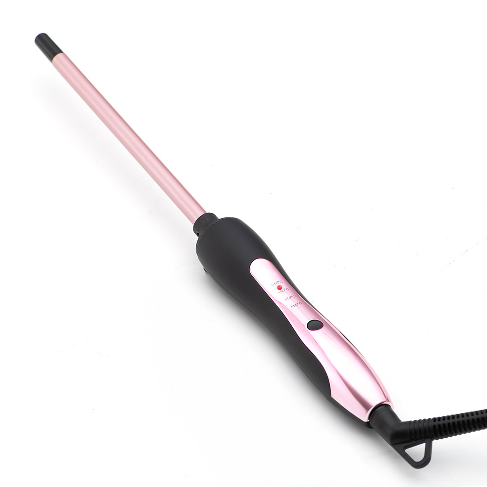 Ein rosa-schwarzer Lockenstab liegt auf einer weißen Oberfläche. Das Eisen ist angewinkelt und zeigt den Lauf und den Griff mit Temperatureinstellungen.