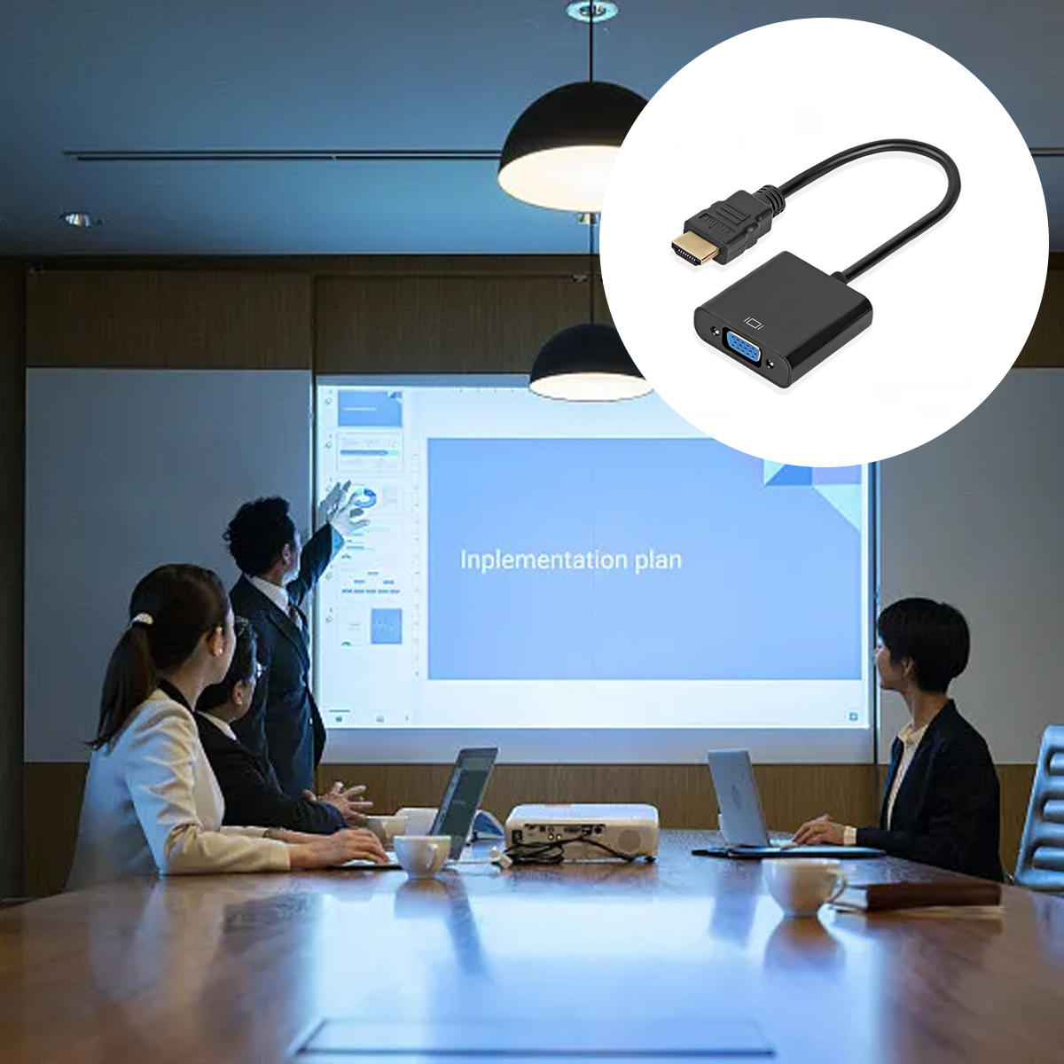 Besprechung im Gange. Personen sitzen um einen Tisch und betrachten eine Präsentation auf einem Bildschirm. Ein HDMI-zu-VGA-Adapter ist abgebildet.