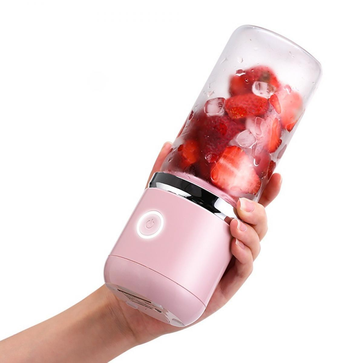 Eine Hand hält einen rosa Mixer, gefüllt mit Erdbeeren und Eis. Der Mixer hat einen Power-Knopf.