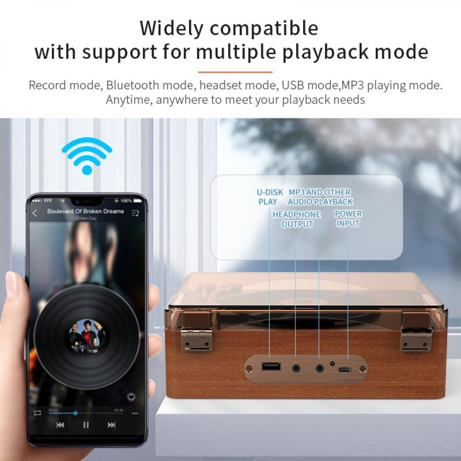 Eine Hand hält ein Telefon, das eine Plattenspieler-App anzeigt. Neben dem Telefon befindet sich ein hölzerner Plattenspieler mit Optionen.