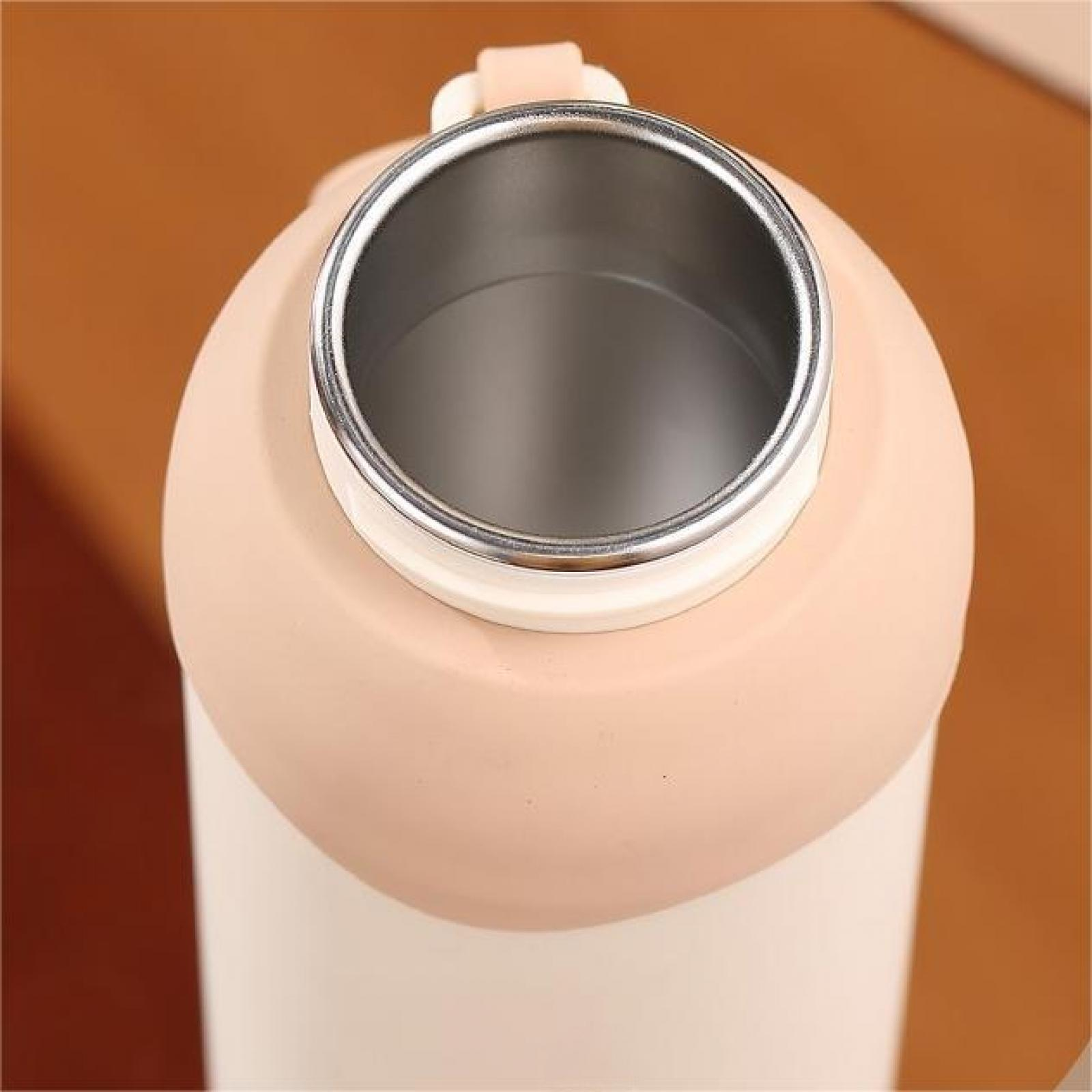 Nahaufnahme einer Wasserflasche. Die Oberseite ist offen und zeigt ein silbernes Innere. Die Flasche ist pfirsichfarben und weiß.