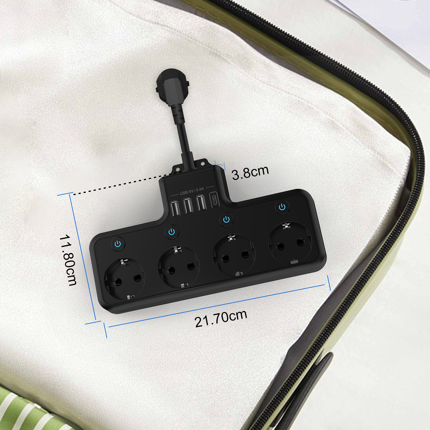Ein schwarzer Stecker mit vier Steckdosen und USB-Anschlüssen liegt auf einer weißen Oberfläche. Es hat beschriftete Abmessungen. Der Hintergrund ist ein Koffer.