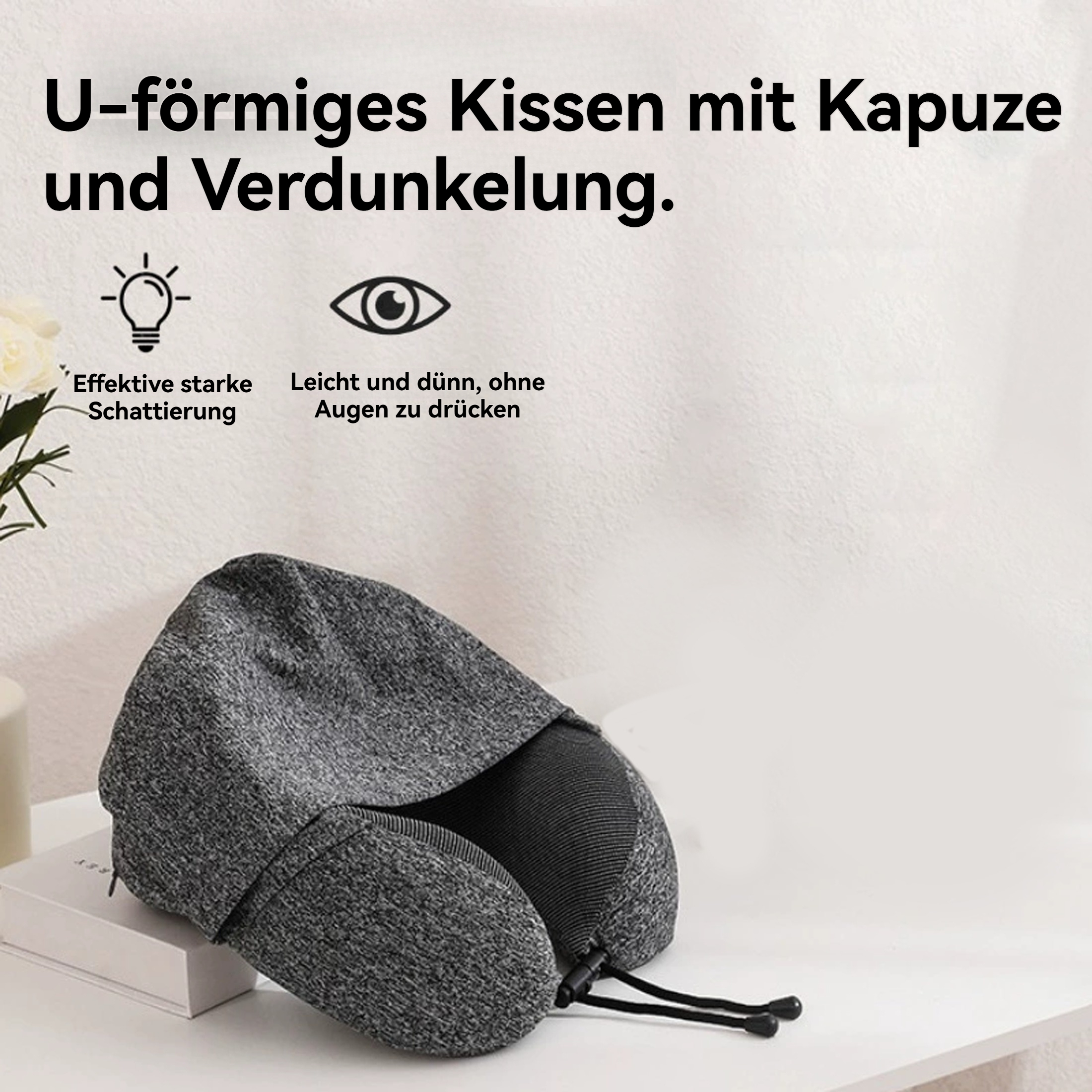 Ein U-förmiges graues Reisekissen mit Kapuze auf einer weißen Oberfläche. Text beschreibt die Eigenschaften.