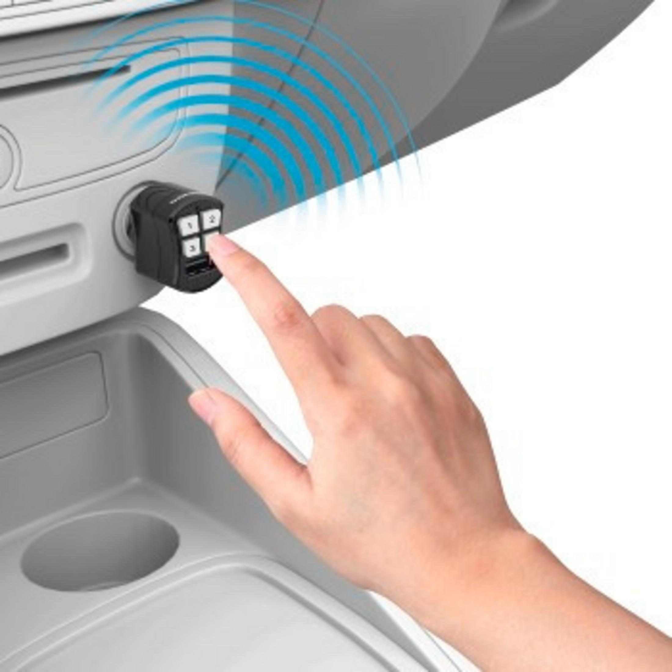 Eine Hand drückt eine Taste an einem schwarzen Autoladegerät. Blaue wellenförmige Linien gehen vom Ladegerät aus, eingebettet in einen grauen Autoinnenraum.