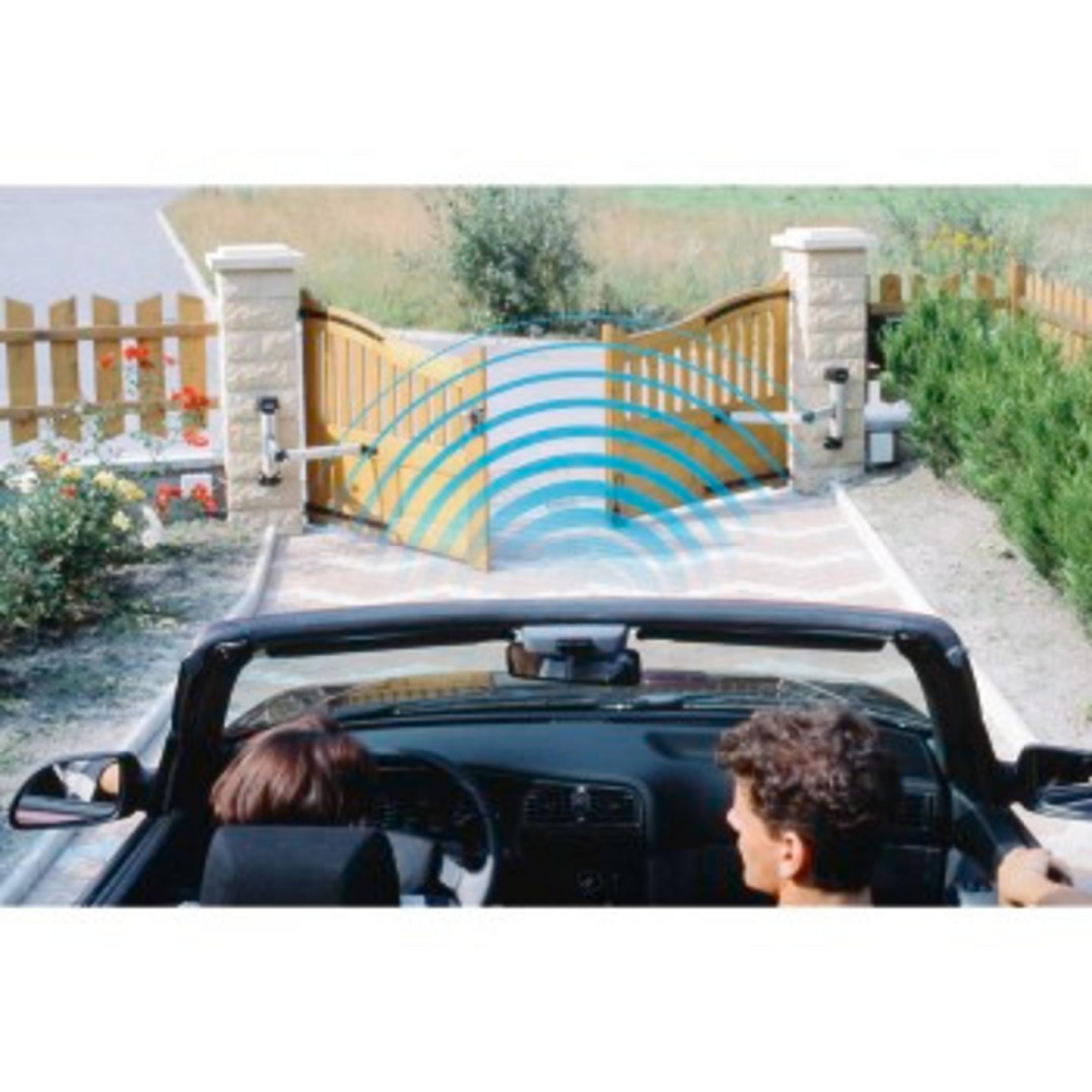 Ein Cabrio nähert sich einem automatischen Tor. Blaue Funkwellen gehen vom Tor aus. Zwei Personen sitzen im Auto.
