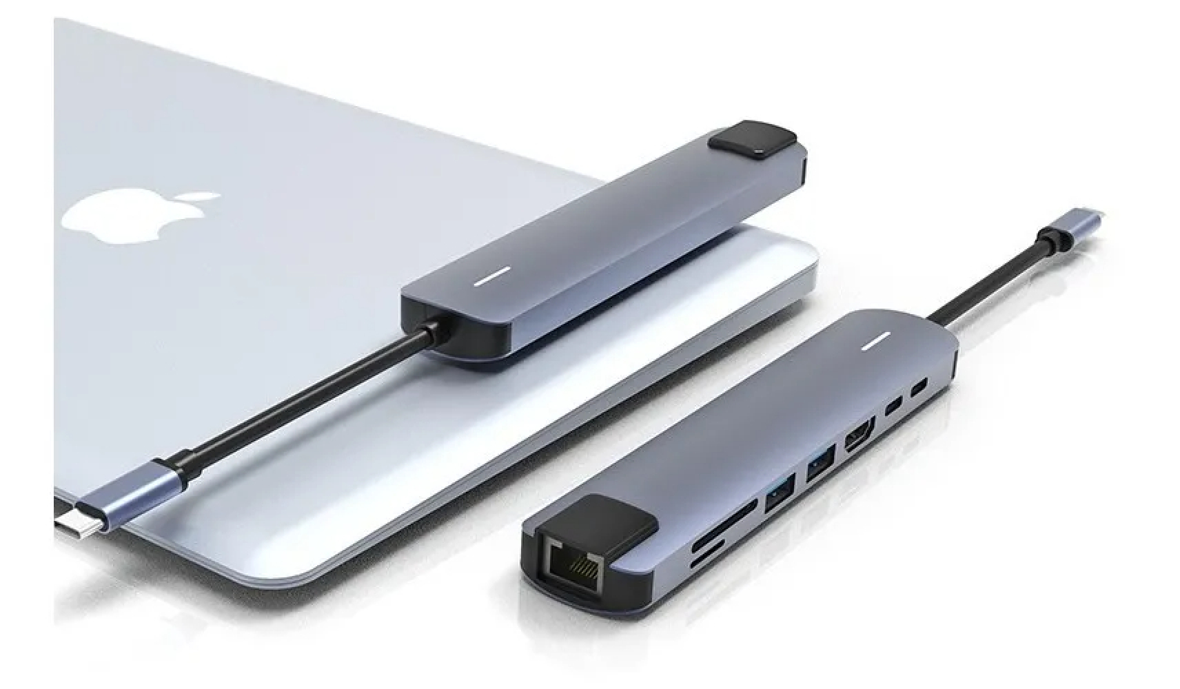 Ein silberner Laptop mit Apple-Logo und zwei grauen USB-C-Hubs. Ein Hub ist über ein schwarzes Kabel mit dem Laptop verbunden.