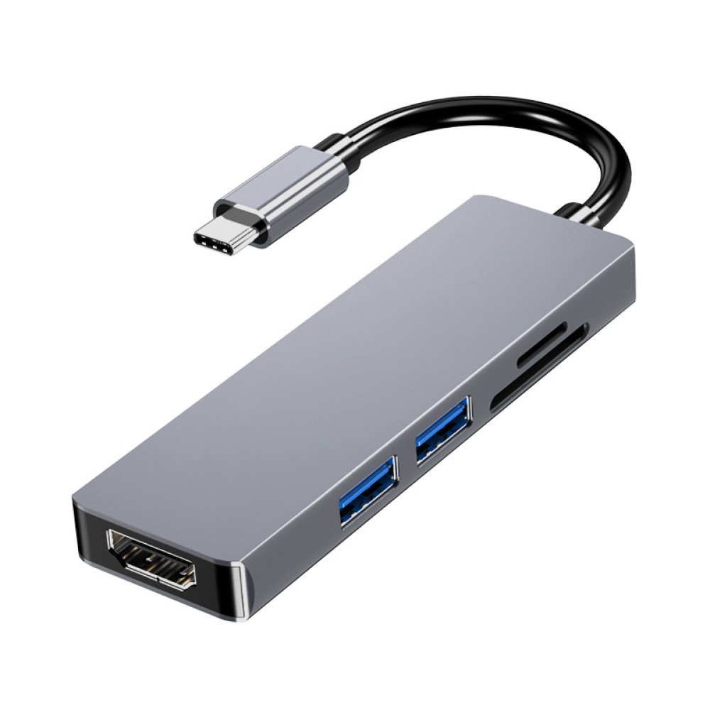 Ein silberner USB-C-Hub mit schwarzem Kabel. Er verfügt über HDMI, USB-Anschlüsse und einen Kartenleser auf weißem Hintergrund.