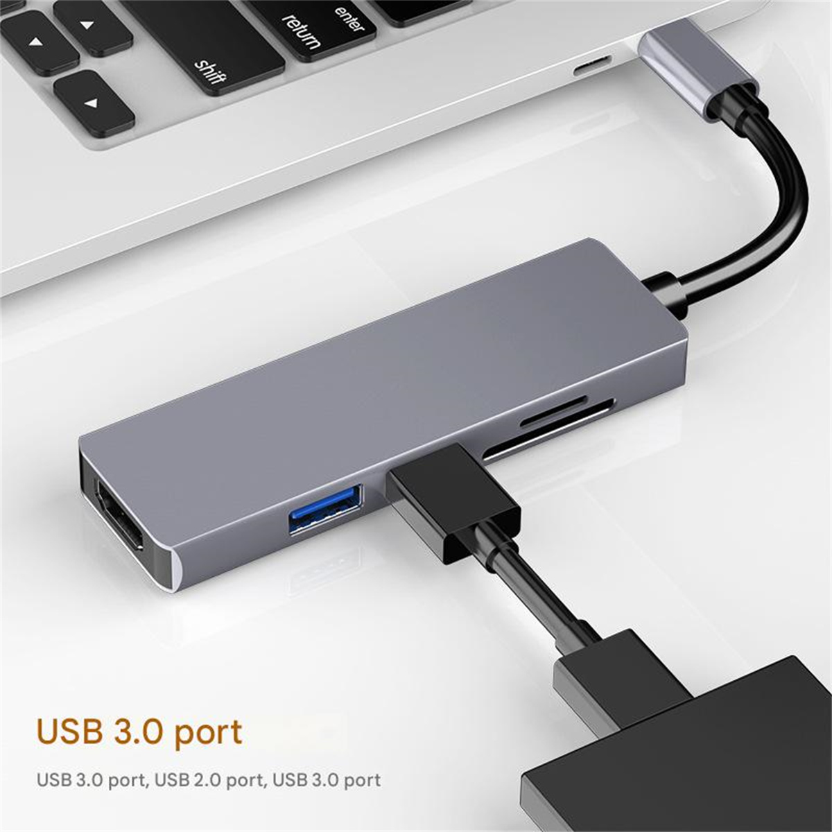 Ein grauer USB-Hub, der mit einem Laptop verbunden ist. Er hat mehrere Anschlüsse, ein schwarzes Kabel und ist mit USB 3.0 beschriftet.