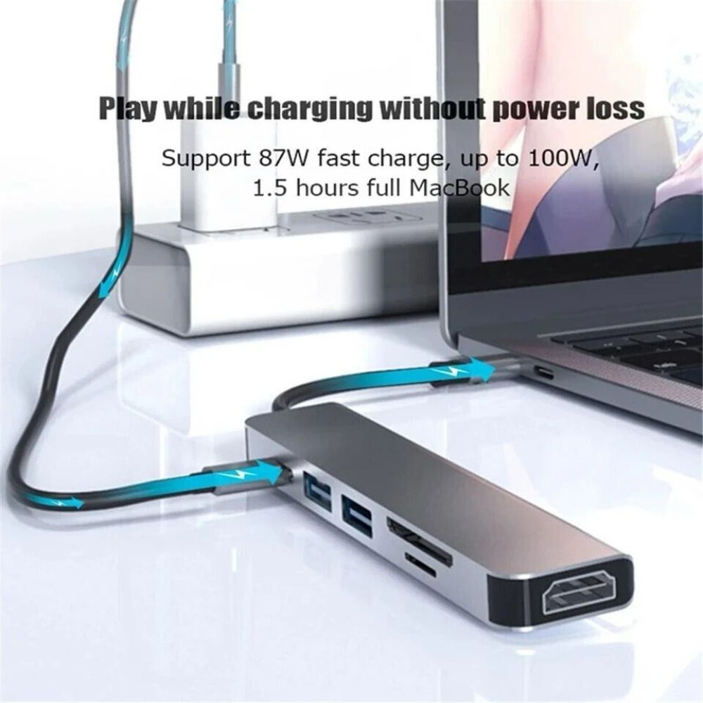 Ein silberner USB-Hub, der mit einem Laptop und einem Netzteil verbunden ist, mit Text über schnelles Aufladen.