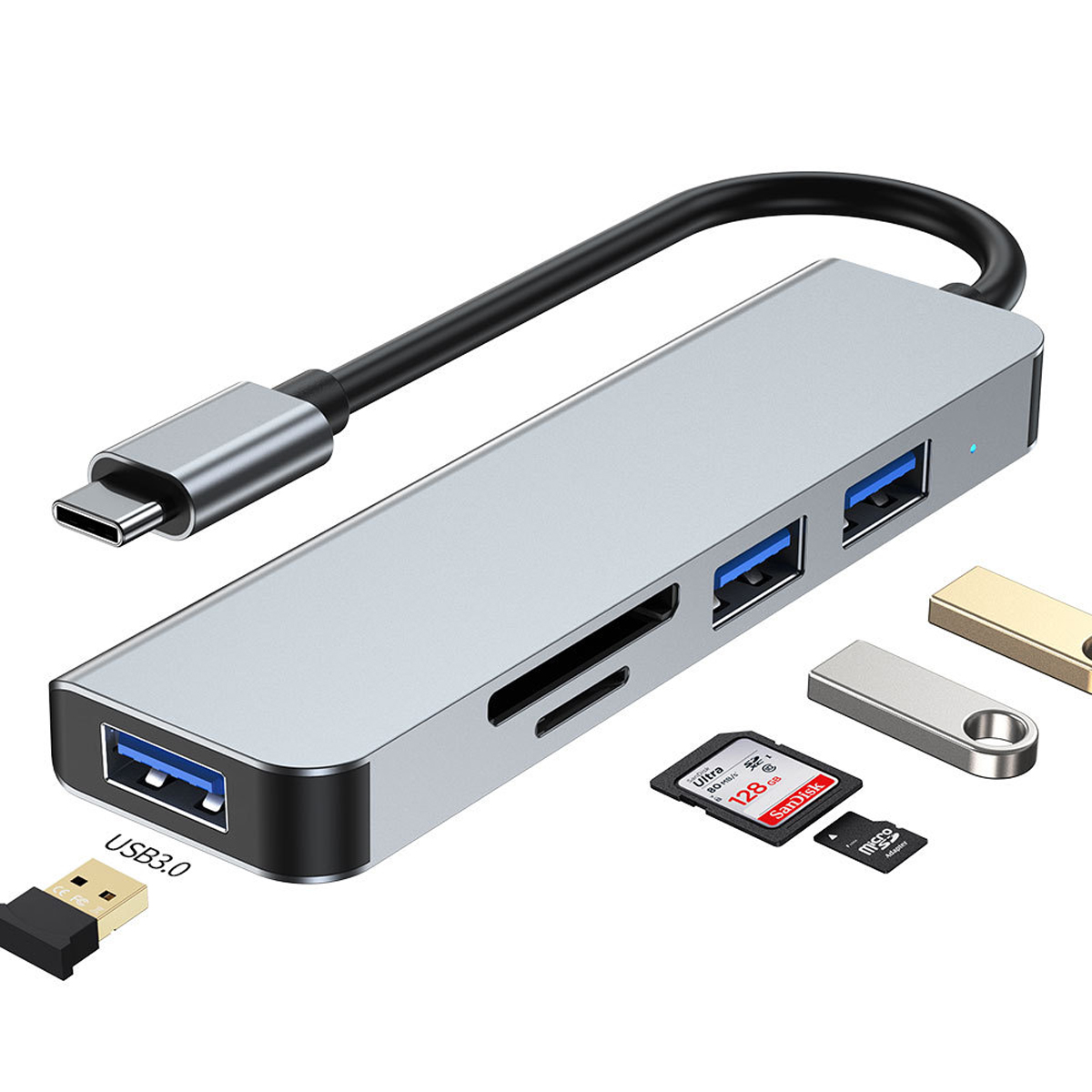 Silberner USB-C-Hub mit mehreren Anschlüssen und Zubehör: USB-Sticks, SD-Karten und ein USB 3.0-Adapter.
