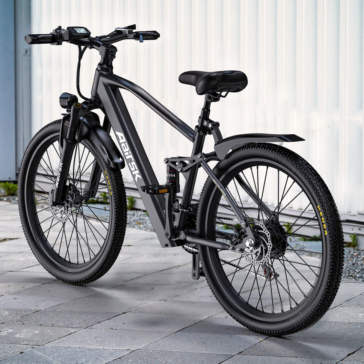 Ein schwarzes Elektrofahrrad steht auf einer gepflasterten Oberfläche. Das Fahrrad hat einen grauen Rahmen, schwarze Reifen und einen schwarzen Sitz. Der Hintergrund ist eine weiße Wand.