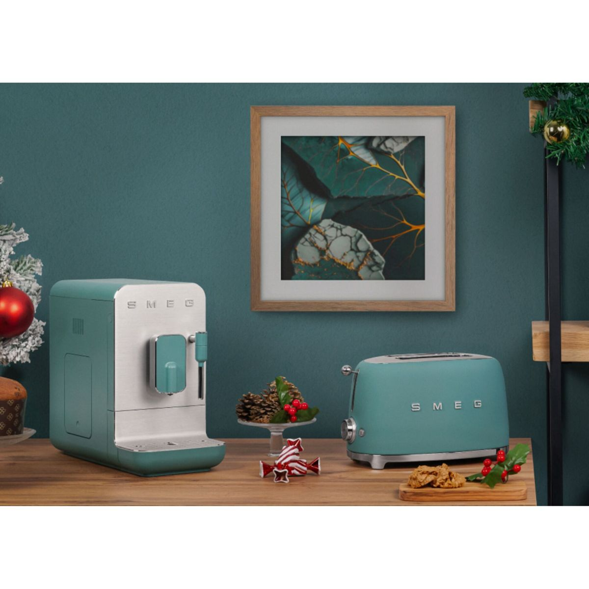 Turkusowy ekspres do kawy i toster stoją na drewnianej powierzchni, z oprawioną grafiką liści. Widoczne są dekoracje świąteczne.