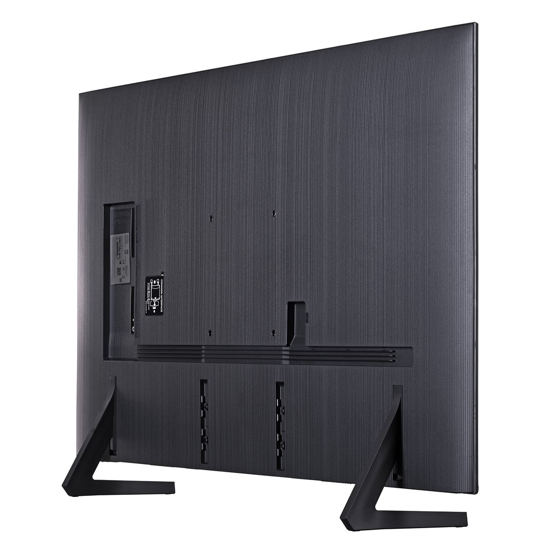 Widok z tyłu dużego, ciemnoszarego telewizora z płaskim ekranem. Ma teksturowaną tylną część, stojak i widoczne porty połączeń.