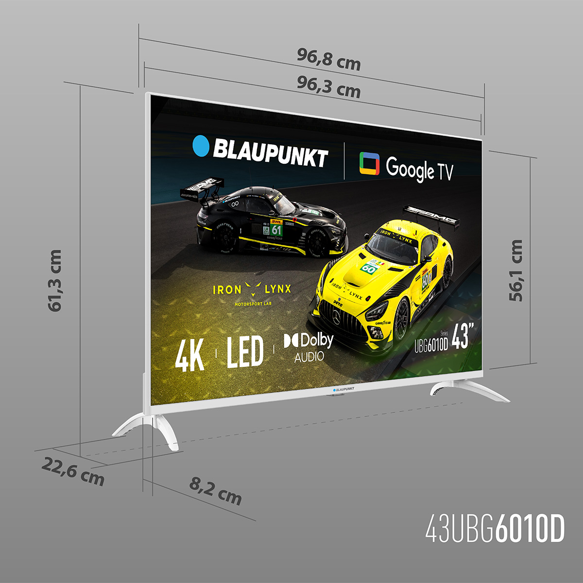Telewizor Blaupunkt 43" wyświetla samochody wyścigowe. Widoczne wymiary i logotypy, w tym Google TV i Dolby Audio. Biała podstawa i wymiary.