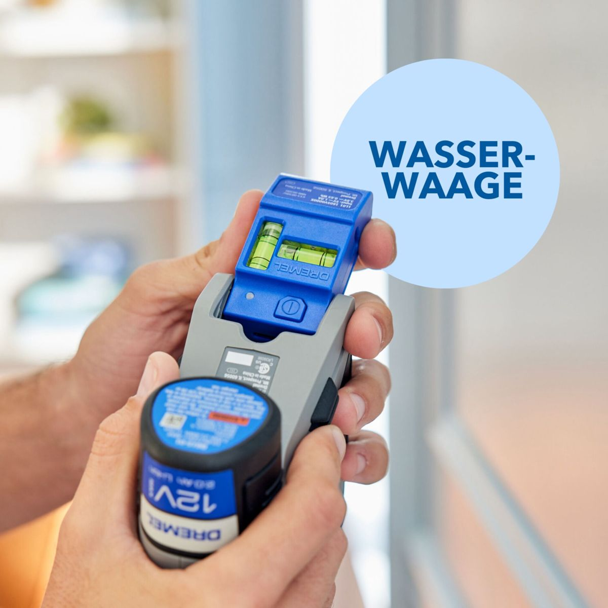 Mains tenant un outil de niveau bleu et gris. Un cercle bleu avec le texte blanc "WASSER-WAAGE" est en arrière-plan.