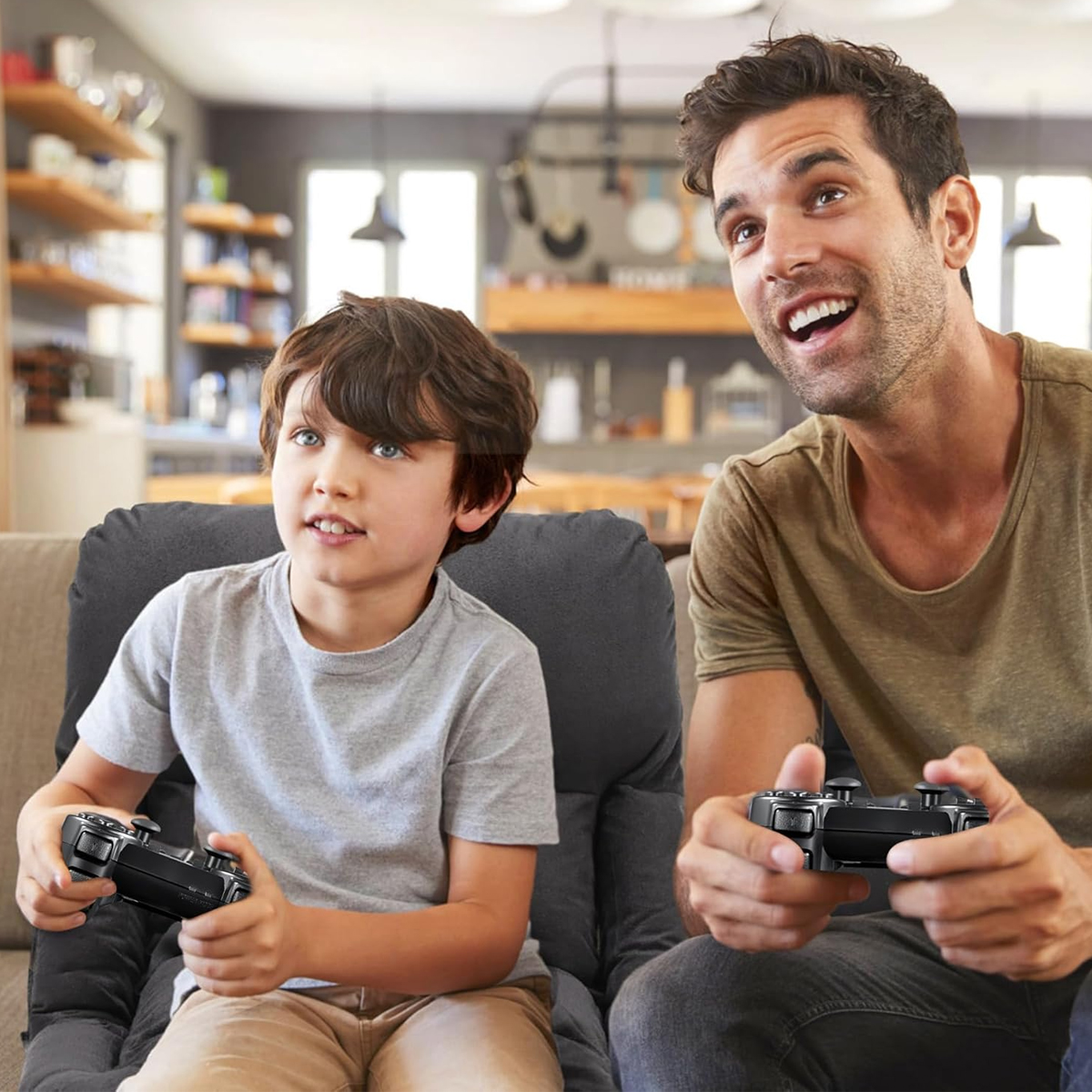 Ein Mann und ein Junge sitzen da, halten Gamecontroller und schauen nach oben. Sie sind in einem Wohnzimmer.