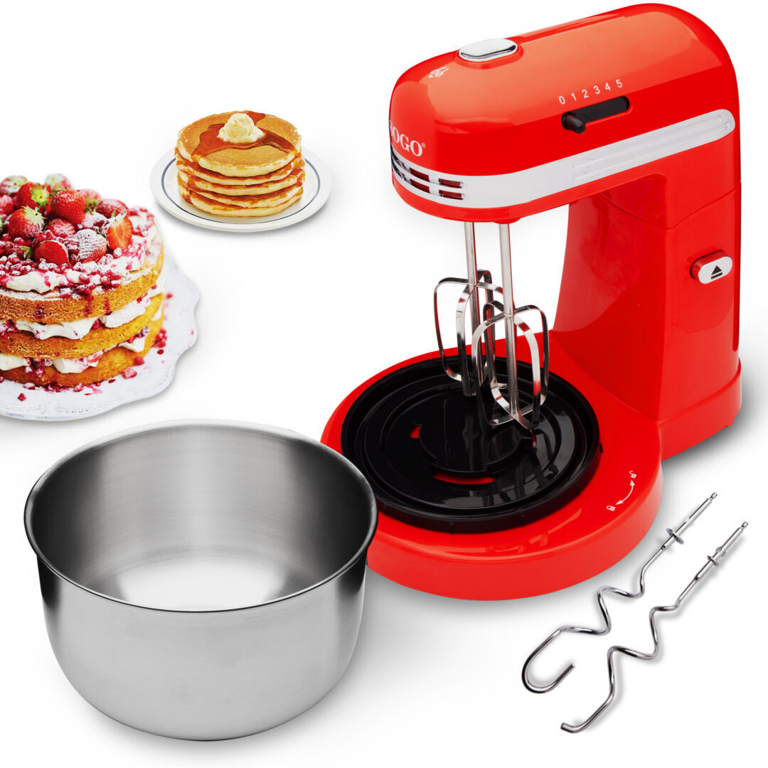 Impastatrice rossa con accessori, torta, pancake e ciotola di metallo. Scena di cottura su sfondo bianco.