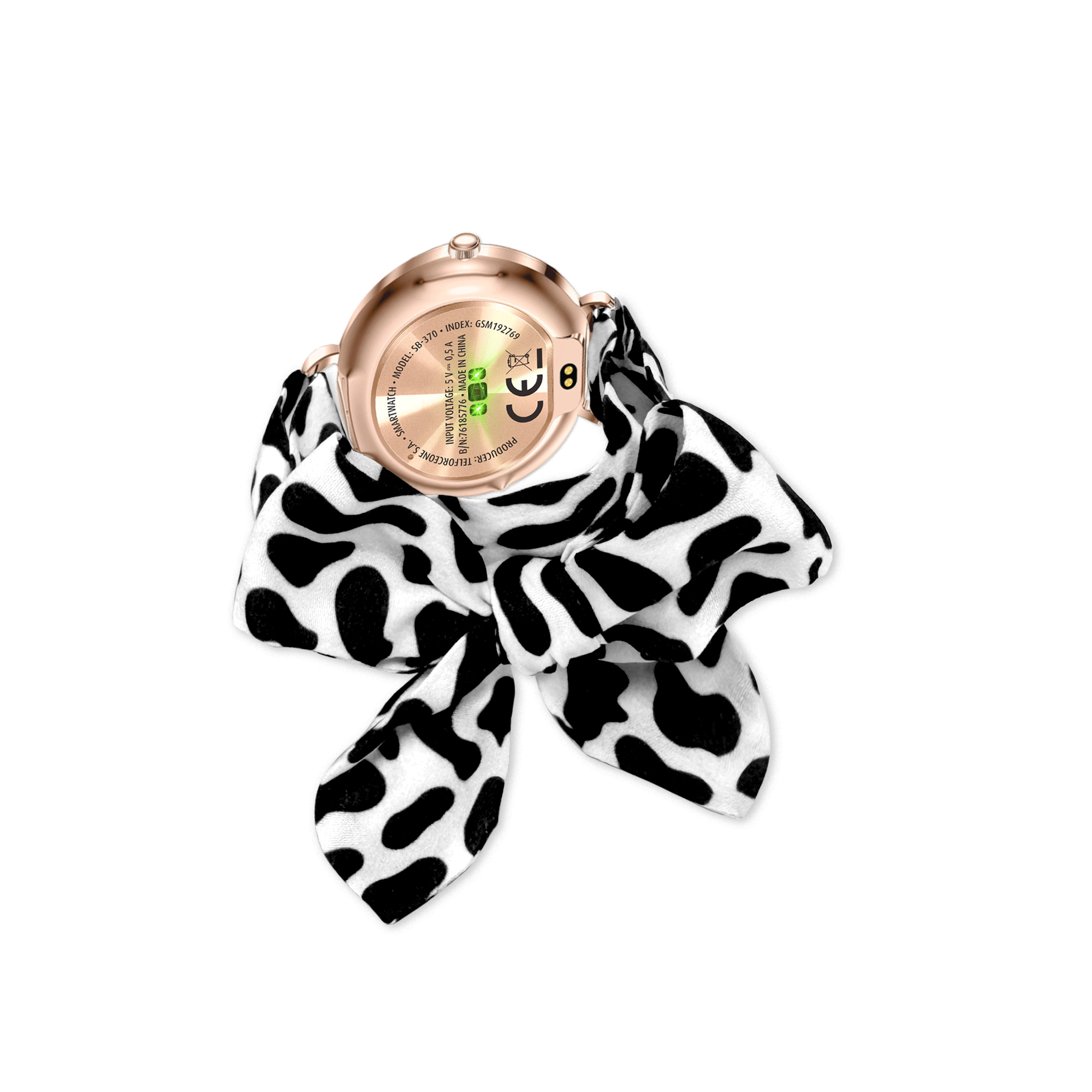 Wyświetlany jest złoty smartwatch, owinięty czarno-białym szalikiem z nadrukiem krowy. Tło jest białe.