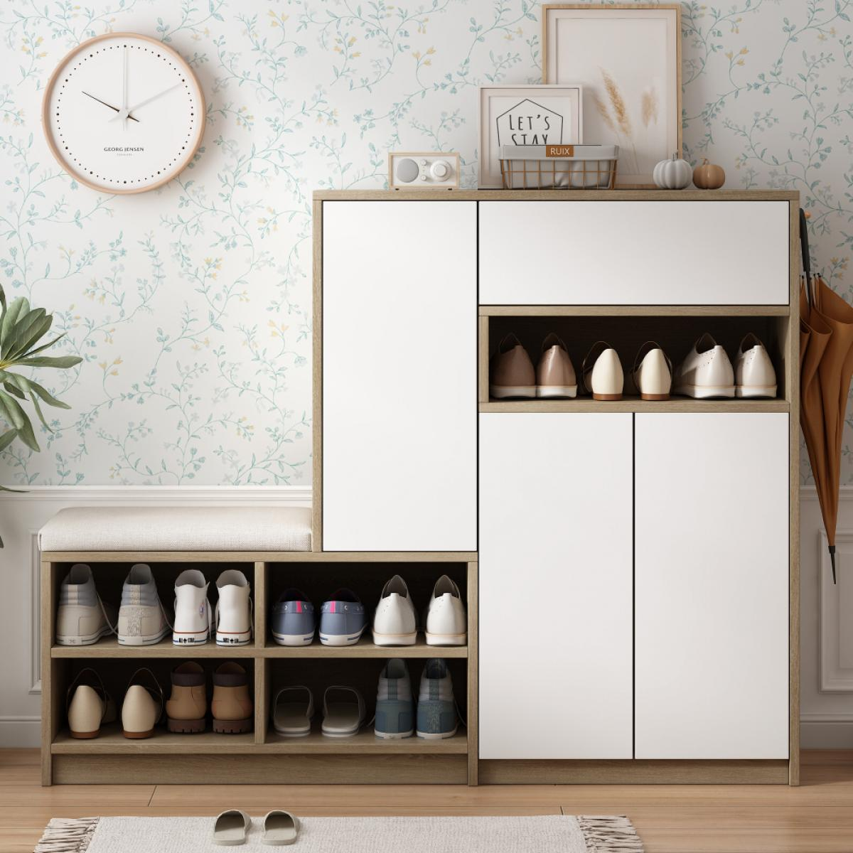Ein Schuhschrank mit weißen Türen, eine Uhr und Schuhe. Eine Bank und ein Regenschirm sind ebenfalls sichtbar. Der Hintergrund ist eine Blumentapete.