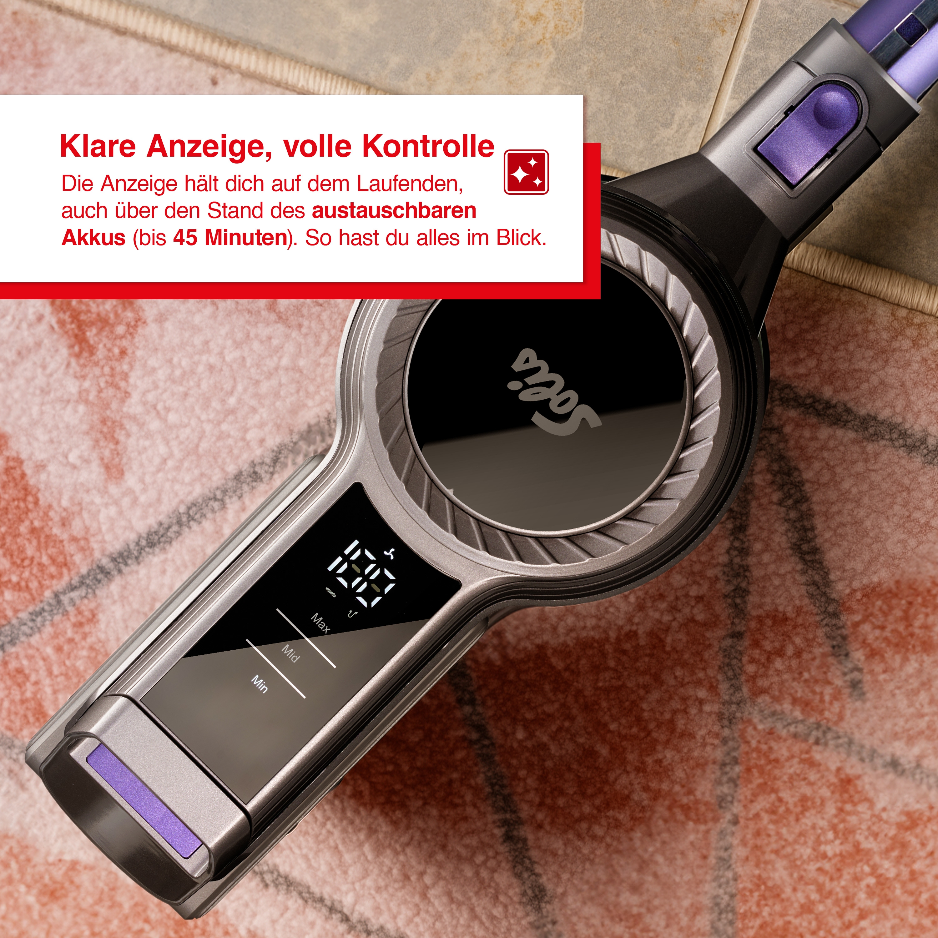 Display dell'aspirapolvere che mostra la durata della batteria e le impostazioni, appoggiato su un tappeto fantasia. Design nero e viola.