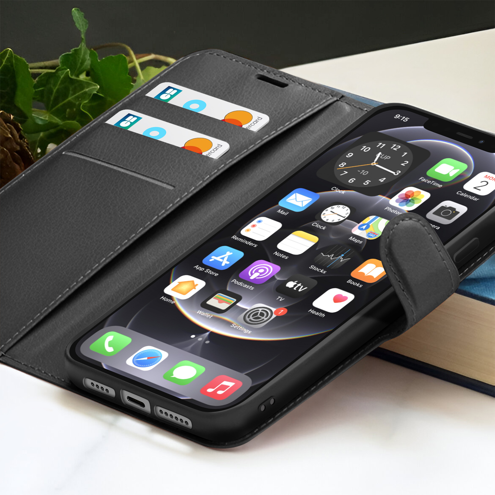 Un iPhone in una custodia nera, che mostra le app. Due carte in un portafoglio grigio. L'orologio segna le 9:15.