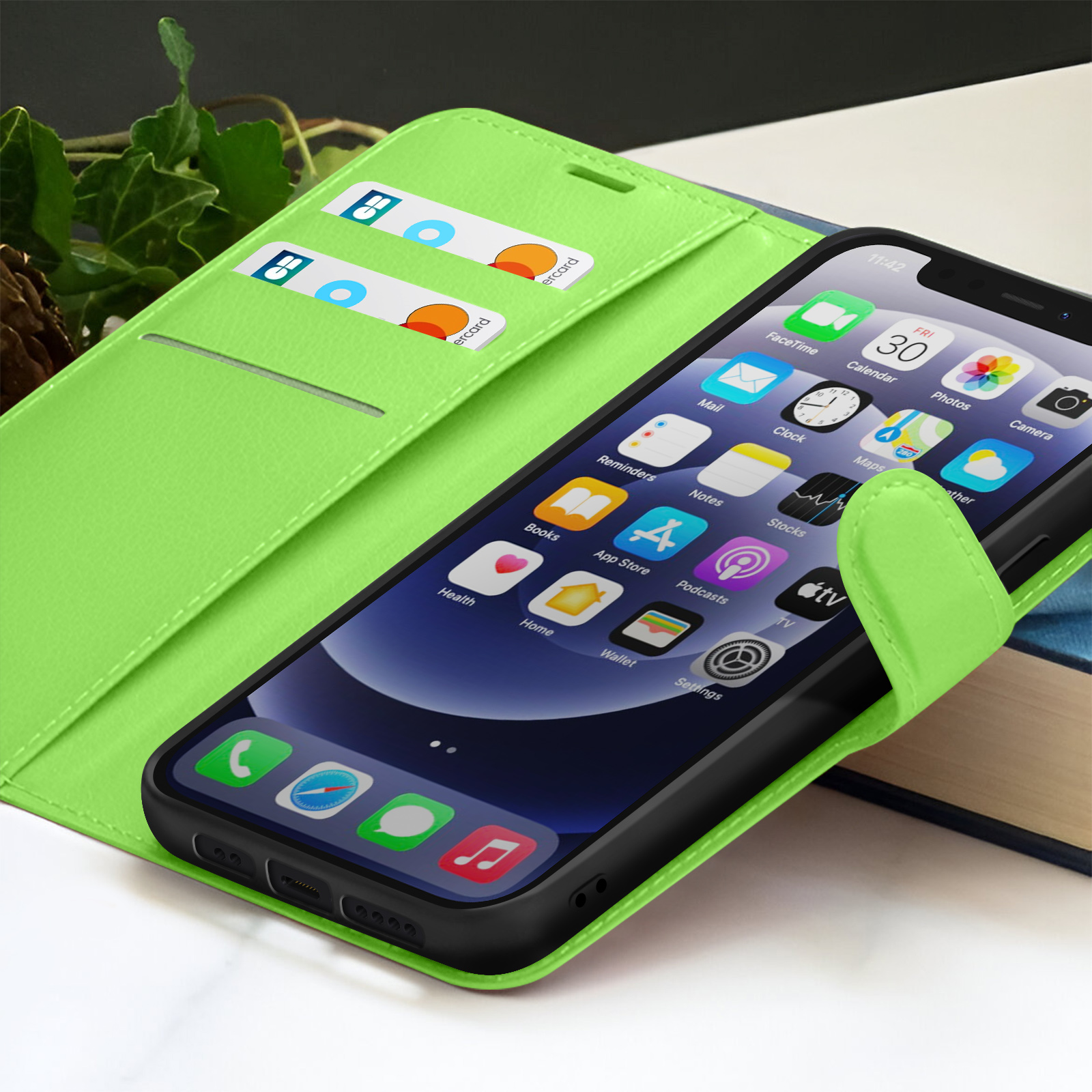 Un étui de téléphone vert avec un téléphone affichant des applications. Deux cartes de crédit sont dans un emplacement. Un livre est en arrière-plan.