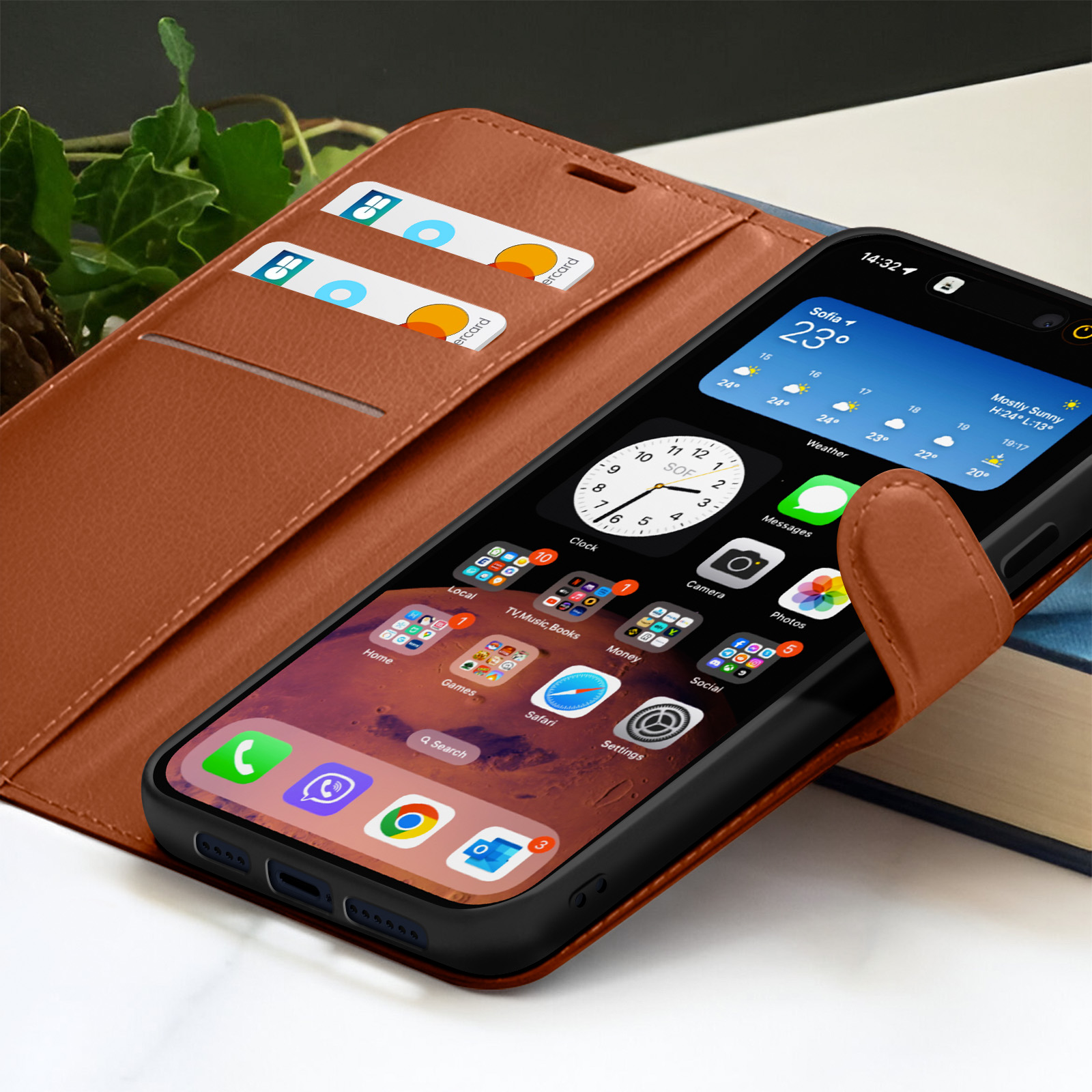 Een smartphone in een bruine leren hoes toont app-iconen. Twee creditcards zitten in een sleuf. De tijd is 14:32.