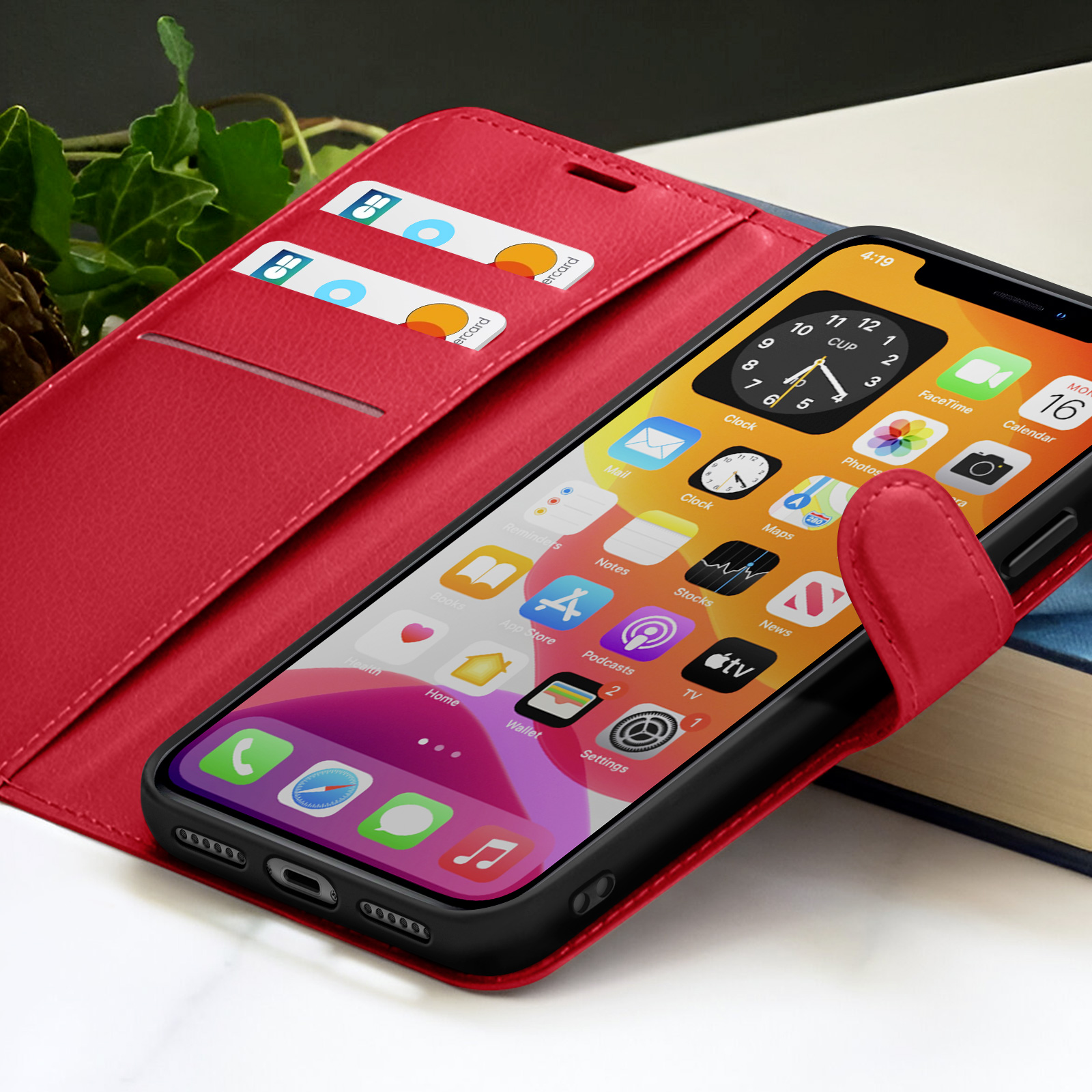 Un iPhone affichant des icônes d'applications est dans un étui en cuir rouge avec des fentes pour cartes de crédit. Une application horloge est ouverte, affichant 4:19.