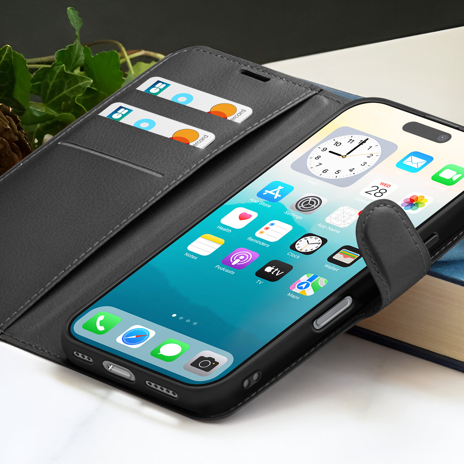 Een smartphone met apps zit in een zwarte hoes met kaartsleuven. Kaarten zijn zichtbaar. De hoes ligt op een boek.