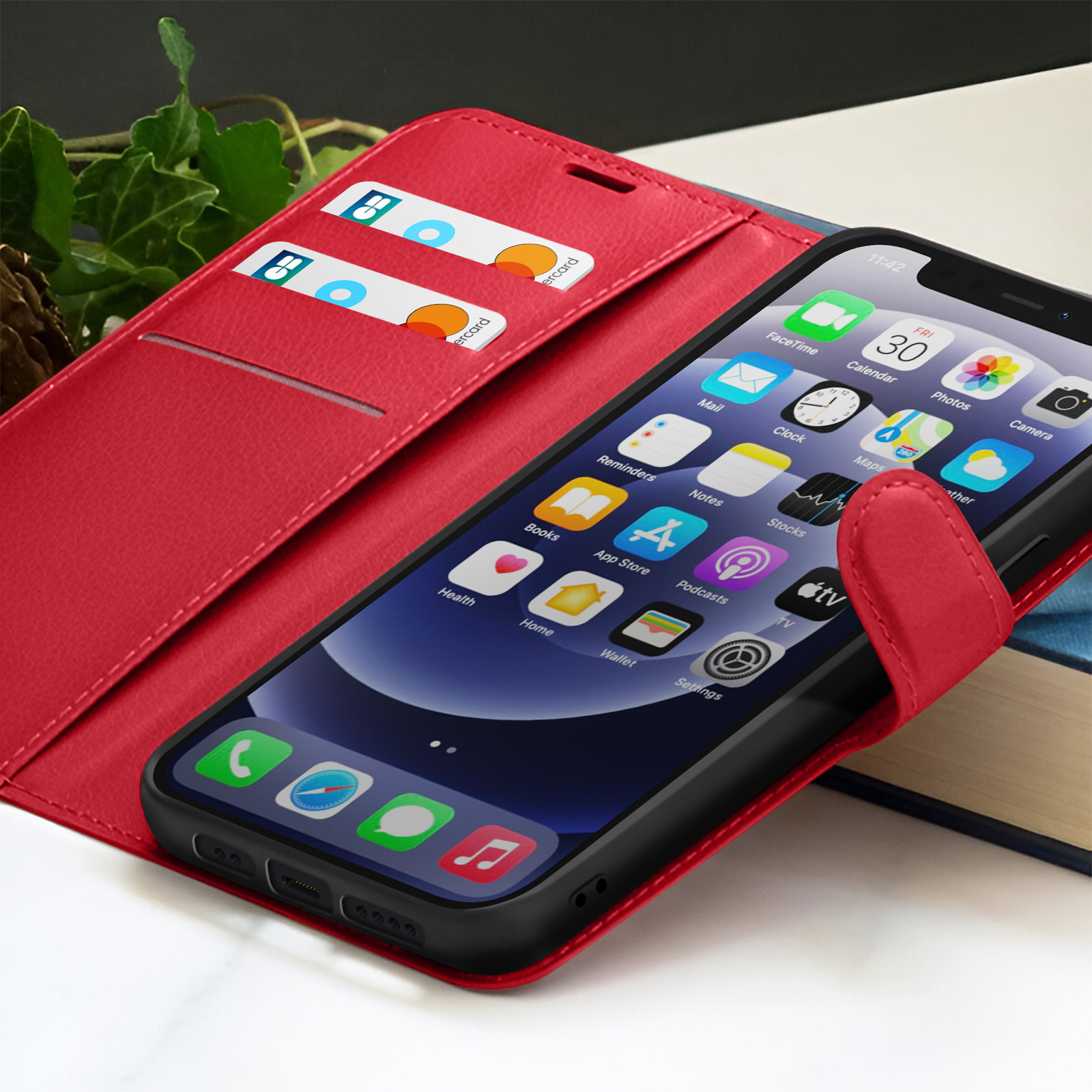 Rode telefoonhoes met een smartphone met app-pictogrammen. Creditcards in een sleuf. Een boek op de achtergrond.