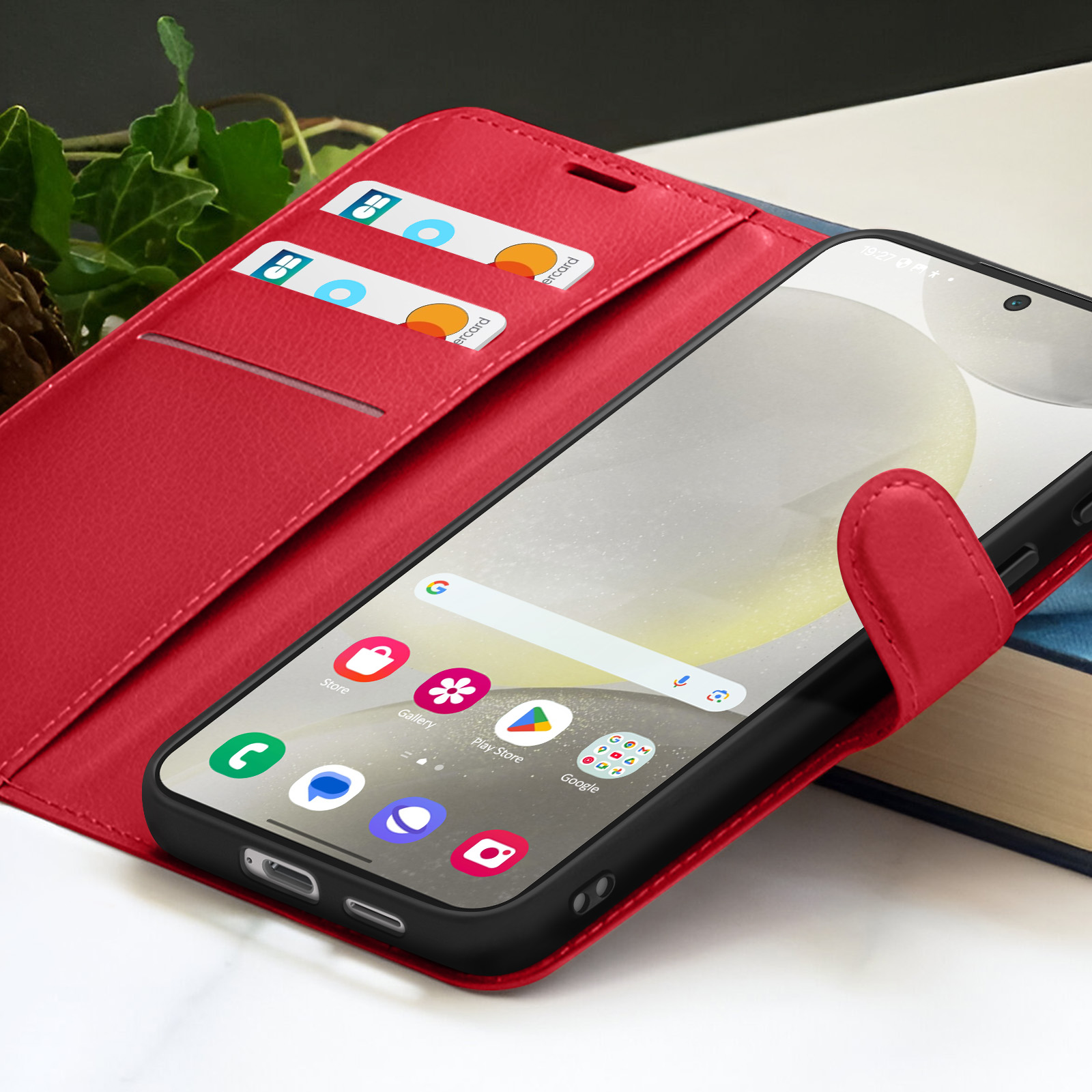 Un étui de téléphone rouge avec un téléphone affichant des icônes d'applications. Des cartes de crédit sont dans l'étui. Un livre est en arrière-plan.