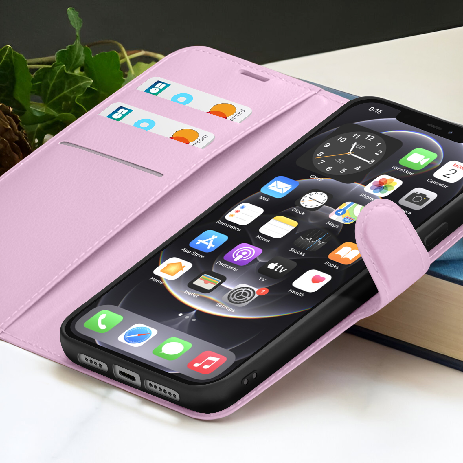 Una custodia rosa per telefono con un telefono che mostra icone di app, un orologio e carte di credito. Un libro è sullo sfondo.