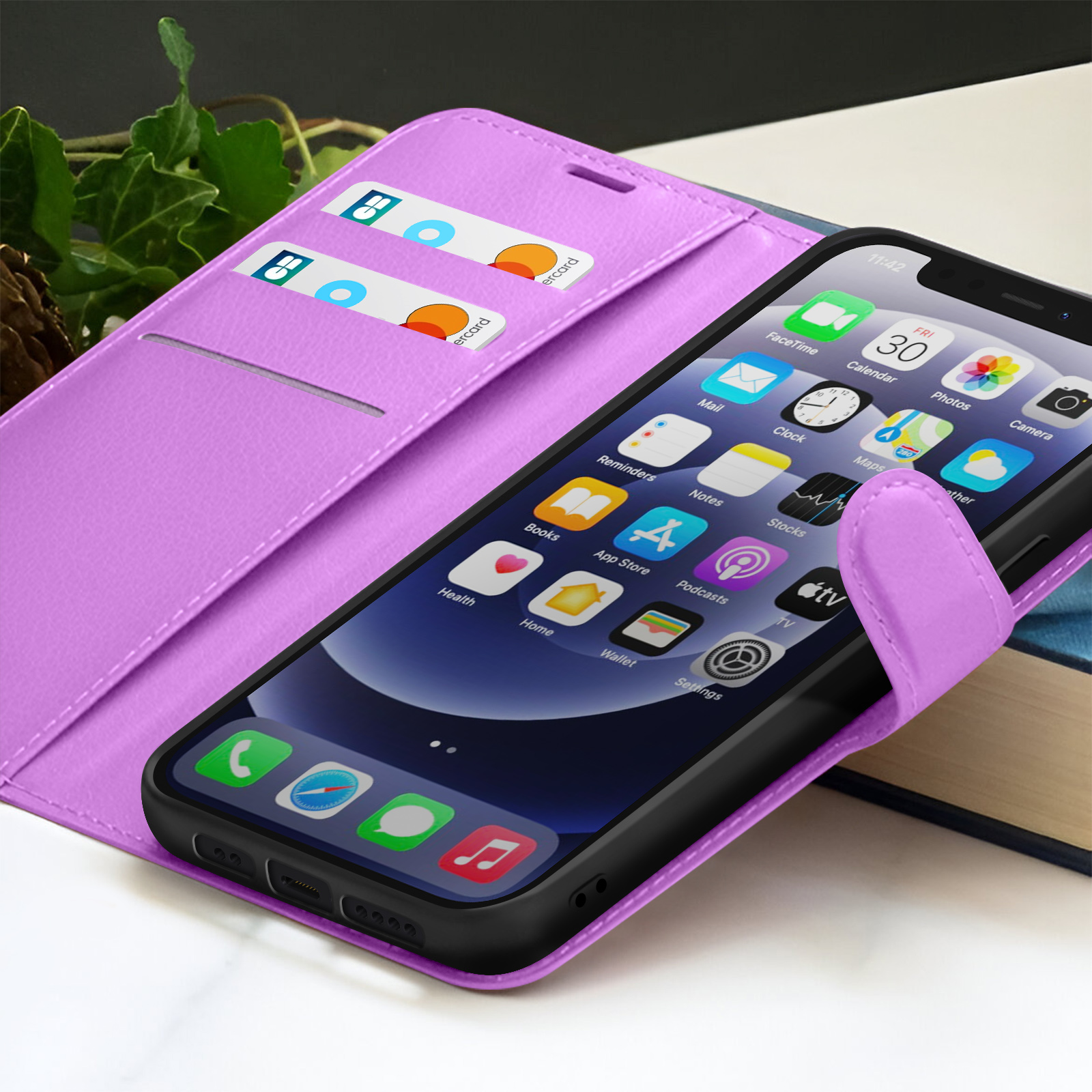 Una custodia per telefono viola con un telefono che mostra le icone delle app è aperta, rivelando le carte. Il telefono è appoggiato a un libro.