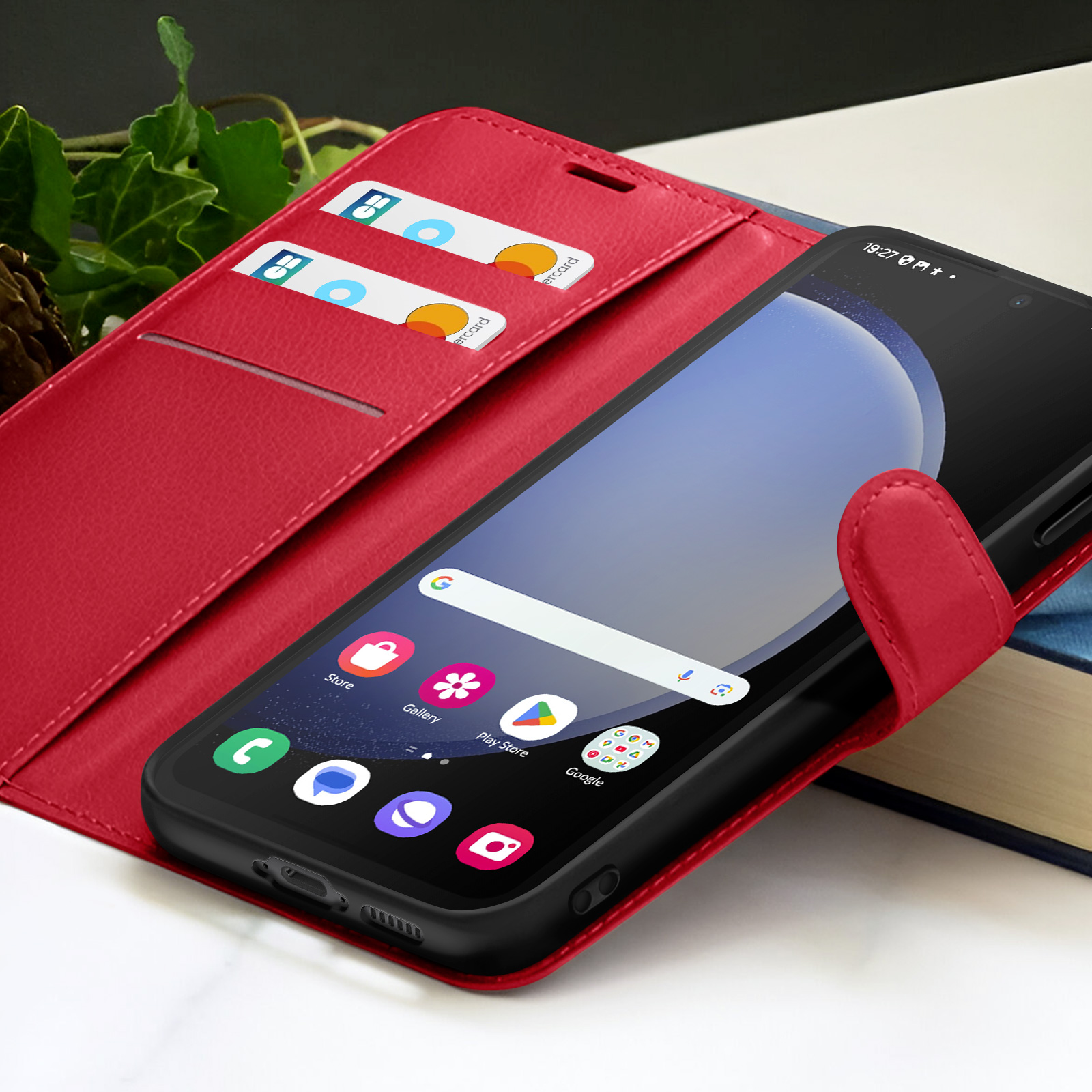 Un étui de téléphone rouge avec un smartphone. A l'intérieur se trouvent des cartes de crédit. Le téléphone affiche un écran d'accueil.