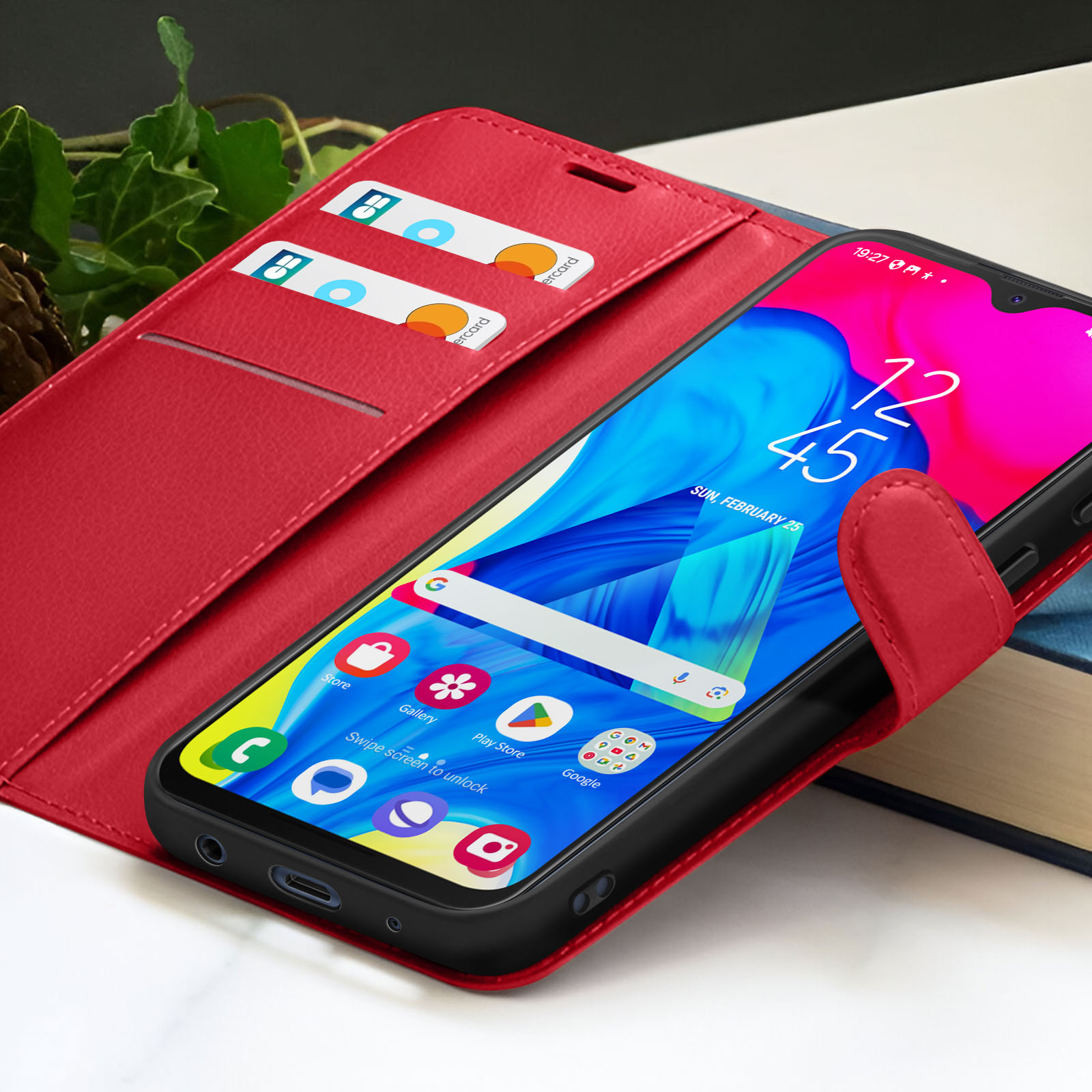 Un étui de téléphone rouge avec un smartphone à l'intérieur. L'écran affiche l'heure et des icônes d'applications. Cartes.