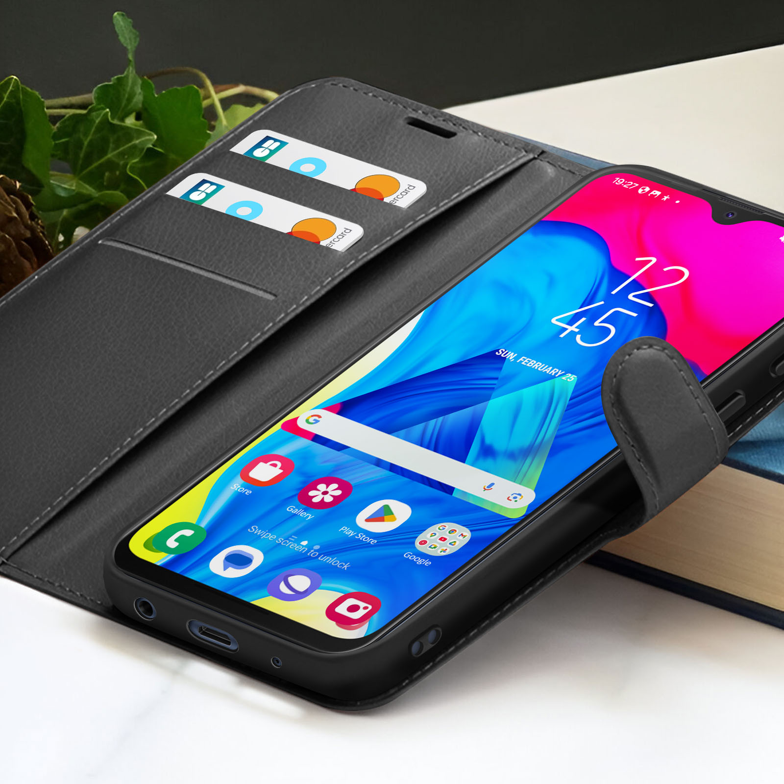 Smartphone dans un étui noir avec cartes de crédit. L'écran affiche l'heure, des applications et un fond bleu et rose.