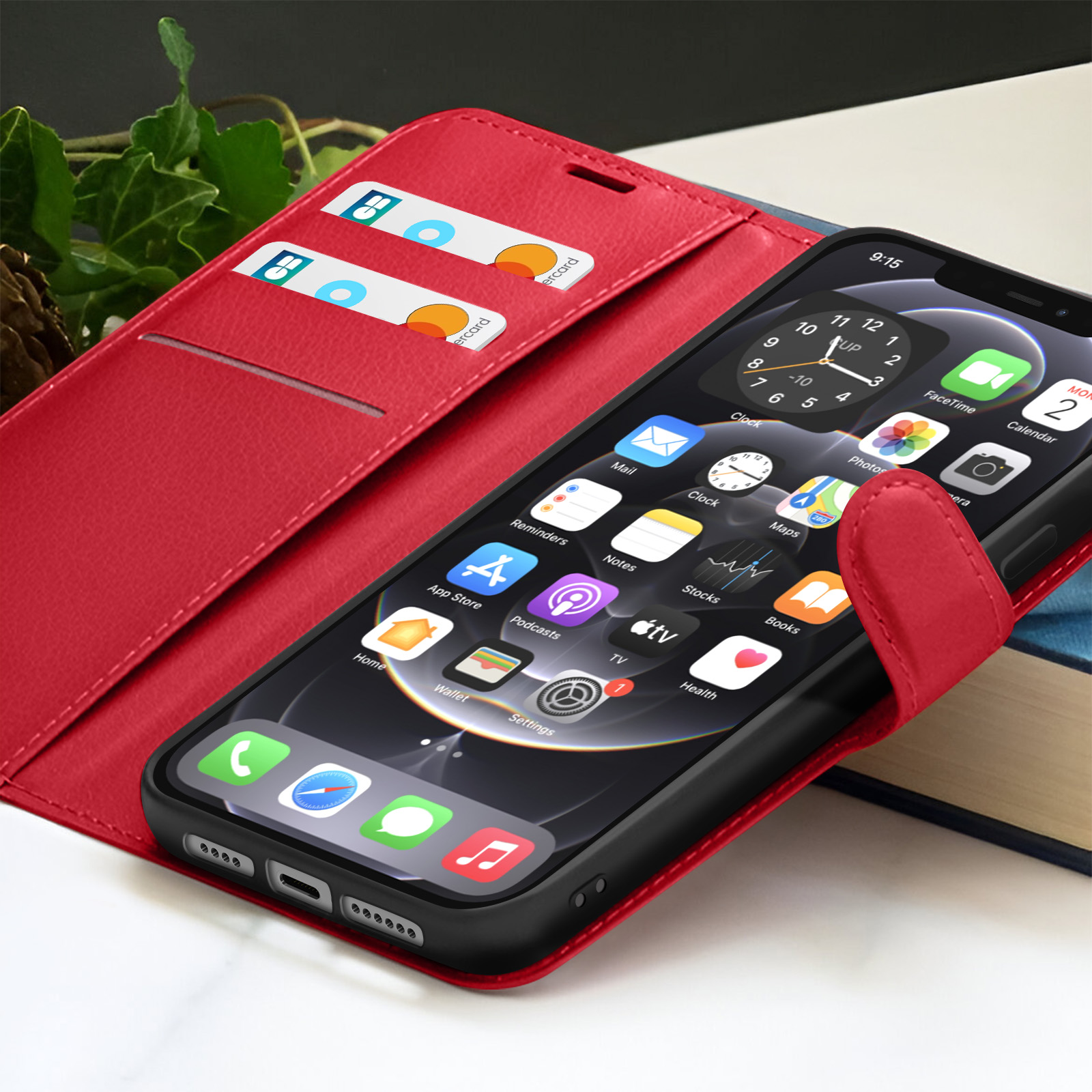 Custodia rossa per telefono con un telefono che mostra le icone delle app. Carte di credito nella custodia. Un libro sullo sfondo.