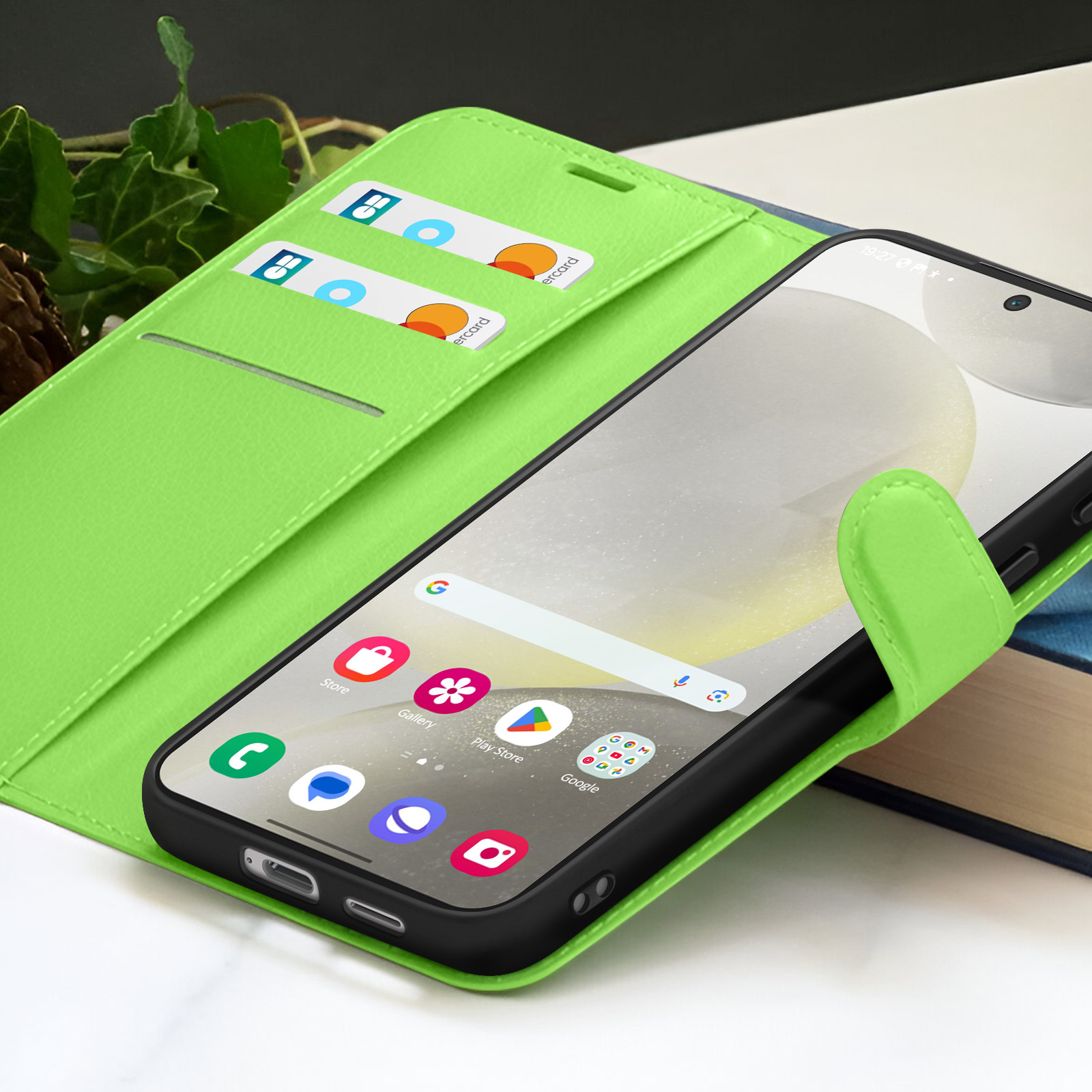 Un smartphone est à l'intérieur d'un étui portefeuille vert citron. Des cartes de crédit sont dans l'étui. Des applications sont visibles à l'écran.
