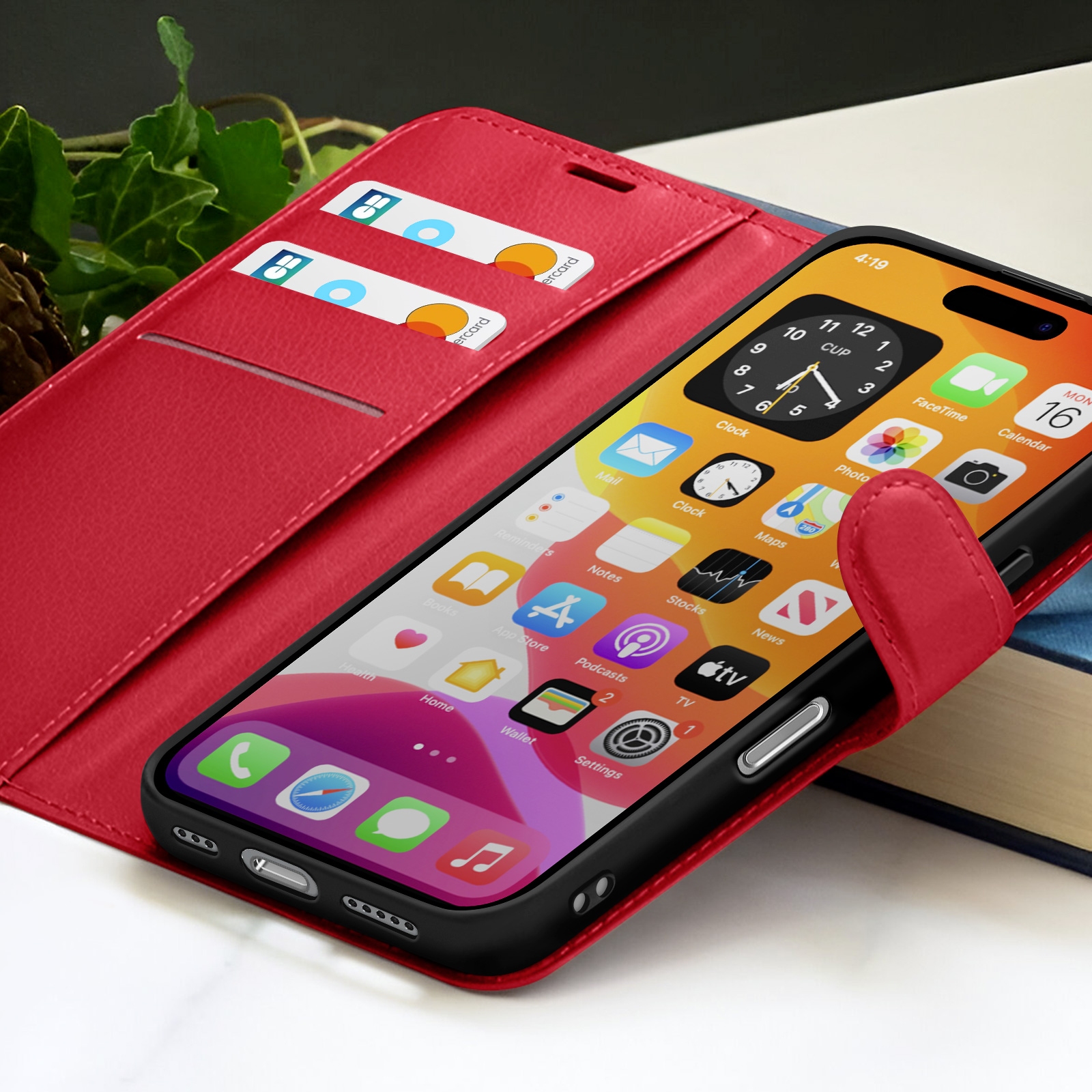 Ein iPhone in einer roten Lederhülle mit Karten. Das Telefon zeigt App-Symbole und die Uhrzeit. Im Hintergrund ein Buch.
