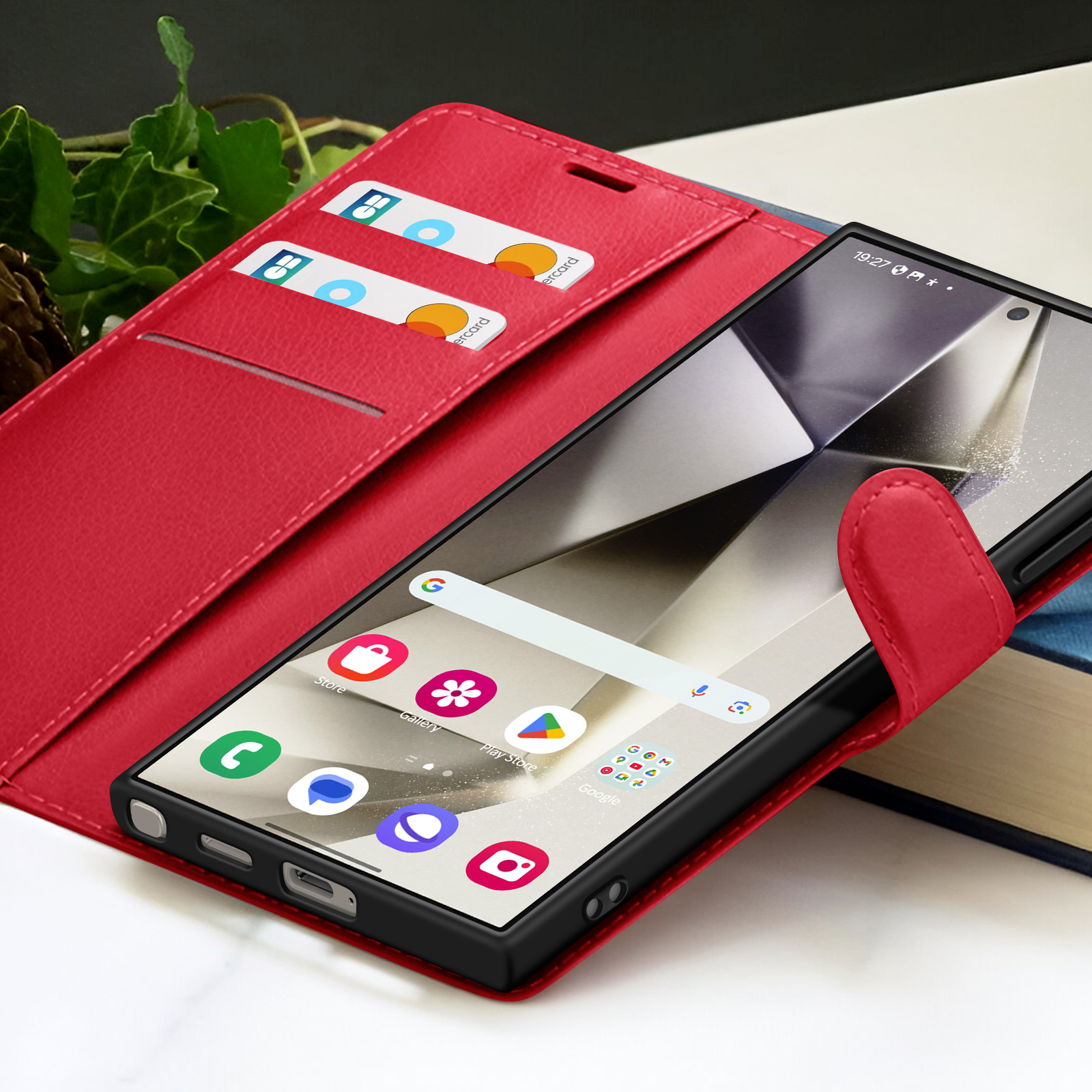 Smartphone in een rode portefeuillehoes. Creditcards in de hoes. Telefoonscherm toont app-iconen. Achtergrond is wazig.