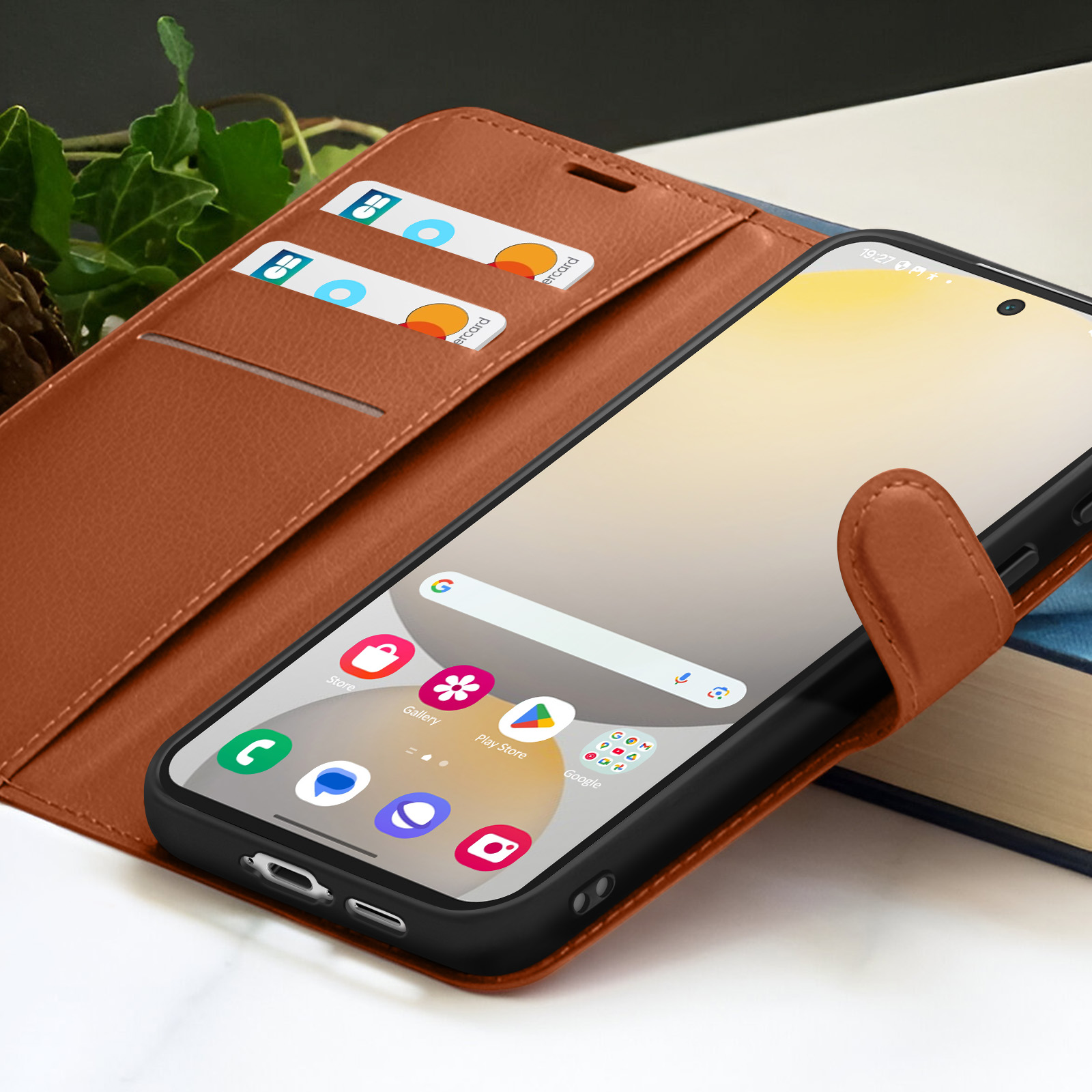 Een telefoon in een bruine leren hoes met creditcards. De telefoon toont app-iconen en de hoes is open.