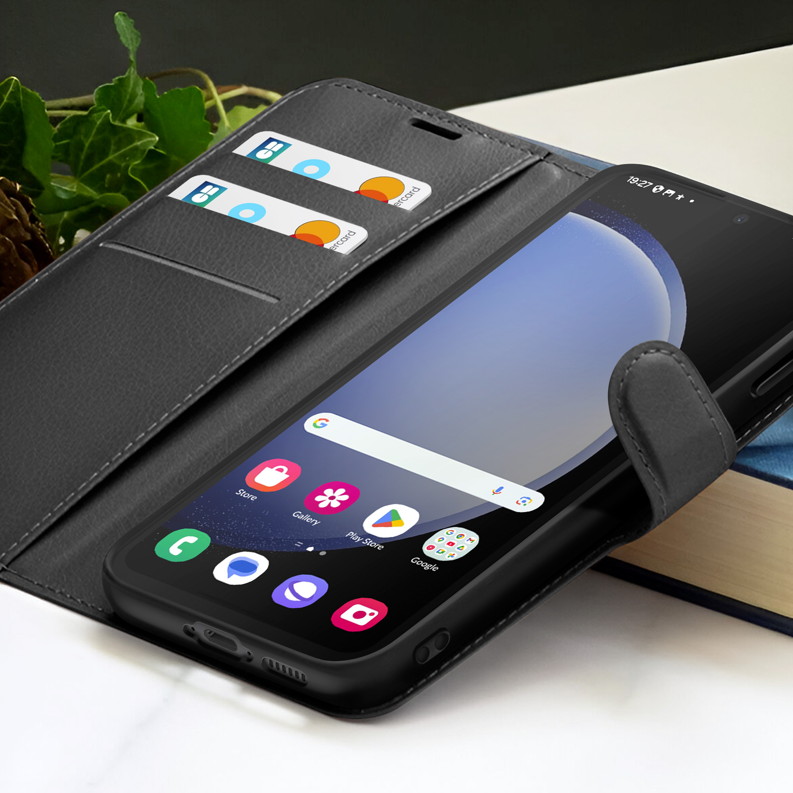 Smartphone noir dans un étui portefeuille. Deux cartes de crédit visibles. Icônes à l'écran : Boutique, Galerie, Play Store, Google.